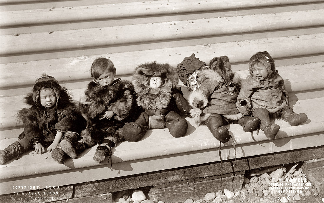 Five small Eskimo children sit bundled in fur garments. Photographed by Frank H. Nowell, the official photographer for the Alaska-Yukon-Pacific Exposition, c. 1908. View full size.