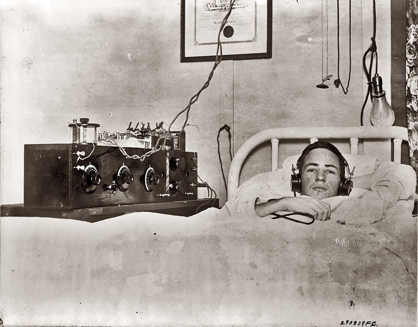 Lester Picker listens to his shortwave radio through earphones while convalescing after breaking his back when he fell 55 feet erecting an aerial for the radio. Photograph by Underwood & Underwood, April 18, 1922. View full size. (Updated with additional information on Lester — click here and scroll down.)