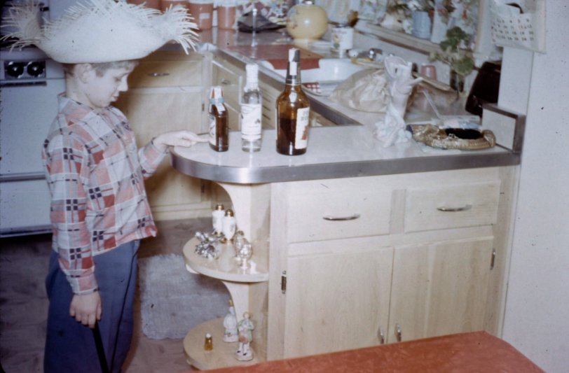 My young father looking at the alcohol in his kitchen in Chicago. He was about six here in 1954. View full size.
