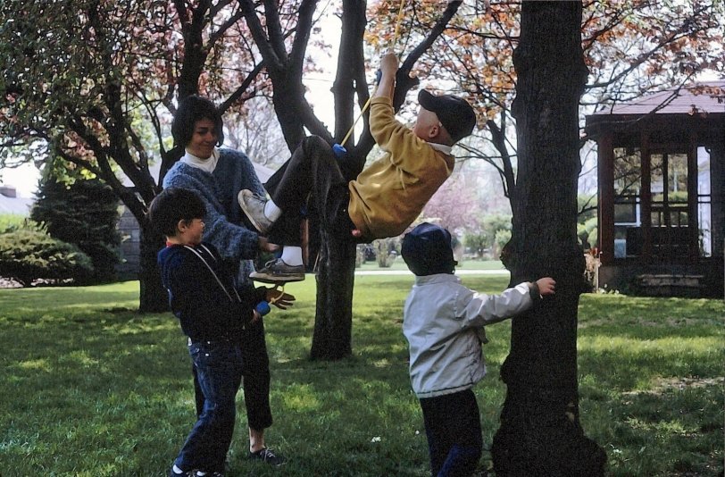 In the backyard of 6643 N. Kilpatrick, Lincolnwood, Illinois. Louise Hurvitz (b. 1933) pushes Terry Lee Sanders (b. 1957) hanging by a rope as her sons Andy (b. 1962) and Jimmy (b. 1964) stand by.  View is to the south. Photograph by Sol A. Hurvitz (1932-2009). View full size.
