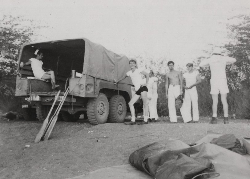 It must have been hot and sticky at Subic Bay, Philippines because these sailors, who are loading or unloading a truck, seem not to be in full uniform. Among the supplies they have are boat paddles, which don’t look real useful for them. Photographed by my father, a fellow sailor.

