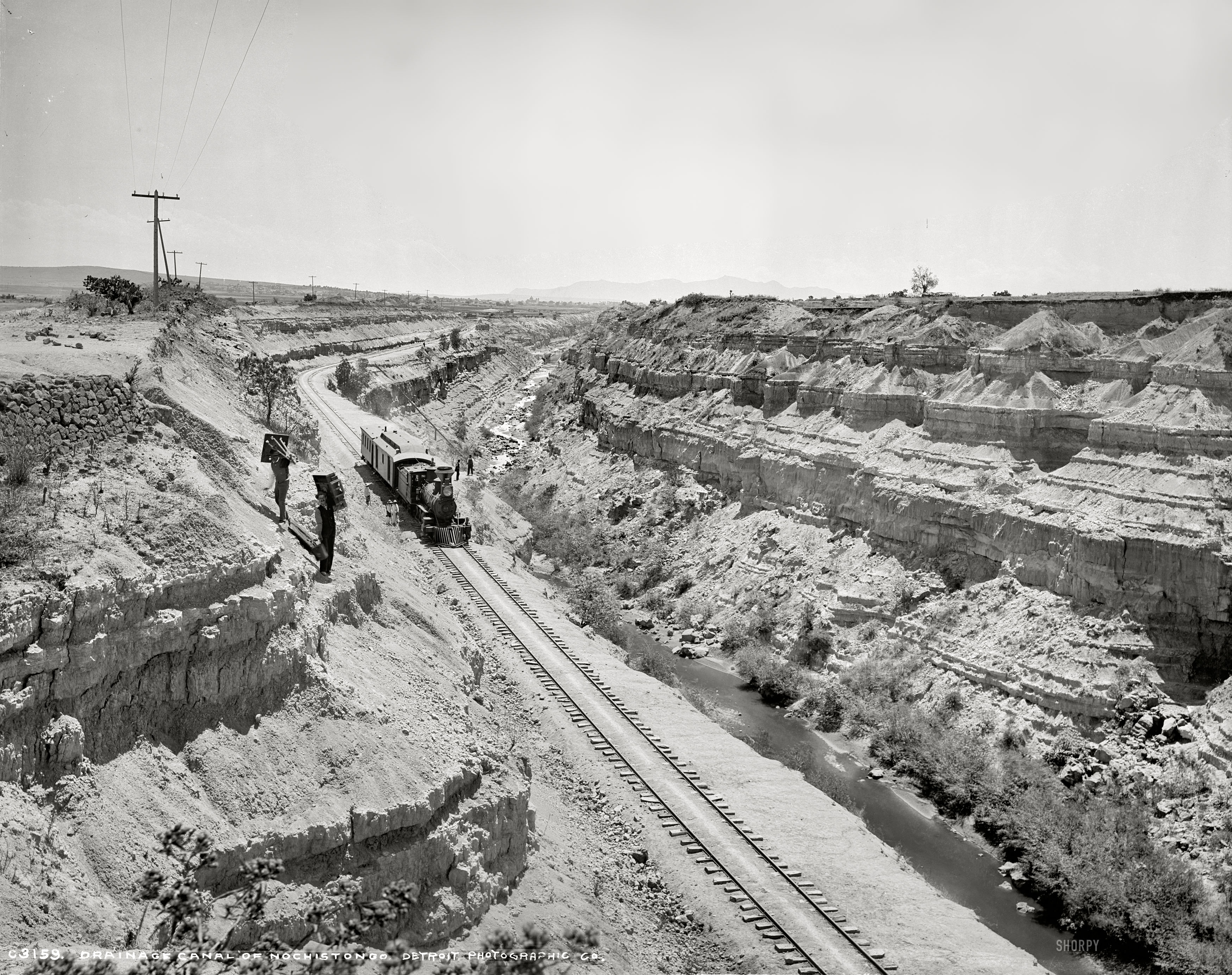 Mexico circa 1891. "Ferrocarill Central Mexicano. Canal of Nochistongo," a drainage excavated in the 17th and 18th centuries to keep Mexico City from flooding. Note the giant camera and tripod employed by William Henry Jackson in the making of his heroically proportioned photographs, the largest of which were recorded on a medium the archivists call "mammoth plates" -- glass negatives that measured 18 by 22 inches. (This particular image was made on an 8x10 inch glass plate -- what modern photographers would consider "large format," but still only a fifth the size of an 18x22.) Detroit Publishing Co. glass negative. View full size.