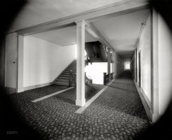 Put-In Bay, Ohio, circa 1898. "Hotel Victory corridor." A door slammed. The maid screamed. 8x10 inch glass negative, Detroit Publishing Co. View full size.
The ShiningWelcome to the Overlook Hotel.
A beautiful resort hotelin its day. Too bad there are not more of these types of hotels left.
TimelessAre you sure this wasn't taken in 1998? It sure looks like it could have been, such fine quality.
CharacterThese old hotels had character, which can be summed up in one word: combustible. I imagine feet clunking up the wooden stairs, and creaking across the wooden subfloor which undoubtedly underlies the carpet. The stairway doubles as a chimney, of course, and every room has a transom, which will all be opened during the summer months. The walls are probably wood lath and plaster. Although many hotels boasted of "fireproof construction," the more useful term "fire rating" had not yet been invented. The knob-and-tube wiring would be the least of your worries.
As much fun as murder mysteries are, most deaths in these places were far more prosaic.
AmenitiesI wonder if the folks checking in at the front desk asked about the availability of Wi-Fi?
Maintenance Nightmare            Acres of carpet and the electric vacuum cleaner will not be invented for a few more years yet. Plus the huge amount of laundry that had to be done everyday without electric washing machines. 
It must have taken an army of employees to keep a hotel operating back in the day.
Your next step, the Twilight ZoneThe things along the corridor on the right are doors.
The things that look just like them on the left are presumably doors too.
But if you step into a left door you fall straight into that brightly lit atrium, or whatever it is, that you get to, down that flight of stairs.
Uhm, no thanks. I don't want to go there.
Erie TinderboxPut-in-Bay was Ohio's Mackinac Island, and the Victory was its Grand Hotel. Advertised as the world's largest summer hotel, it hosted many national conventions (including one in 1901 for fire insurance agents). By August 1919 it was a pile of ashes, burned to the ground in a spectacular fire.   
DanglersWatch out for low hanging lighting.
RealityThanks Lectrogeek68 for reminding all of us of the downside of vintage construction, etc. Makes you appreciate modern building codes for their safety! Now when you can combine classic architecture, high quality craftsmanship, and modern day conveniences and safety, then you really have something!
CombustibleOne of the world's largest hotels, the Hotel Victory, opened its 625 rooms to the public in 1892. The four-story hotel featured a thousand-seat dining room. However on August 14, 1919, the giant hotel burned to the ground. Today only parts of the foundations can be seen at the state campground.
-- Wikipedia
Suddenly a pirate ship ... appeared on the horizon!
Dave, is there no corner of pop culture with which you are not familiar?
Electric LightsLectrogeek might get a kick out of this old New York hotel sign for guests encountering electric lights for the first time. My mother stole it during a stay at an ancient hotel in the '50s. I never thought to ask her which one.
[Wow. Amazing! Props to your mom. - Dave]
I wonder who was playing in the piano barI'm betting it was Pat Dailey. He's always playing somewhere near Put in Bay.
Hotel CaliforniaYou can check in but you can never leave.
But First, A SongWell, since my baby left me,
I found a new place to dwell.
It's down at the end of lonely street
at Heartbreak Hotel. 
The FireThe Mansfield News Ohio -- August 15, 1919
Sandusky, Aug. 15. -- Fifty guests were driven from their rooms, losing all of their belongings and damage estimated from $500,000 to $1,000,000 was caused last night when the Hotel Victory at Put In Bay burned to the ground.
The structure, one of the most famous hostelries on the lakes, contained 625 rooms in addition to a large dining room, parlors and ball room. The origin of the flames is unknown, the blaze starting in a cupola and enveloping the entire third floor before persons in the hotel were aware that it was on fire. Word was telephoned to the hotel from outside of the fire.
The huge structure burned like tinder and the blaze was visible for miles around the lakes. Crowds gathered at many points to watch the flames shoot high in the sky.
The hotel was built in 1891 at a cost of over a million dollars, but has never been a paying proposition. A Chicago company headed by Charles J. Stoops bought the hotel this spring and had refurnished it. They carried some insurance but Ben Mowrey, manager, was not aware of the amount of the insurance.
The &quot;Key&quot;The "key" that one was to turn was a surface-mount rotary switch, seen to the left of the stairway. They come up on eBay from time to time, and I own a few. Here is one that I found a couple of years ago, in the basement of a 1917 house in San Antonio. Presumably, it's still there. I didn't remove it.
Electric LightsBryharms picture of that notice about electric lights reminded me of a story about Will Rogers that I heard quite some time ago. It seems that he and a friend checked into a hotel that had gaslights. They had never seen gaslights and, when they retired for the night, they blew out the flames as they would for a coal oil lamp. Luckily, they did not gas themselves but were very sick the next morning. We may laugh about the two incidents today but what new technology is just around the corner that we may not understand to begin with?
The West WingNot Aaron Sorkin's "West Wing", Edward Gorey's.  I fully expect to see a card or three tennis shoes lying on the floor, or a darkly dressed lady in an Edwardian hat on the stairs, or *something* disappearing around the edge of a doorway.
That window at the end of the hallreally bothers me! It almost looks as if it's a portal to another dimension, or an alternate universe, or something. Might be a time-travel hole of some sort, who knows -- it could be 2011 on the other side!
(The Gallery, DPC)