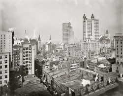 Circa 1900. "New York financial district from the Woodbridge Building." The Park Row building at right was the world's tallest office tower. View full size.
St. Paul BuildingLeft of the Park Row is the 26-story St. Paul Building, built 1895-1898 and demolished in 1958. It was one of the last skyscrapers designed by George B. Post, a pioneer of tall building construction in New York. Alas, it was not well received by the architectural critics of the time, and they were thinking primarily of the front of the building. What we see here are the naked backsides of the St. Paul and Park Row.
What a PictureThis one is amazing. Manhattan in 1901. I see laundry hanging on lines. Not an automobile or a window air conditioner. Not an airplane or a dirigible. Not  a TV antenna or a radio transmitting tower. What we have is the turn of the last century that would create more scientific paraphernalia in a few years than the world saw since its inception.
Wireless Mast!Early radio. Gotta love it.
Gotham GothicAnd people complain about "glass box" skyscrapers! This is one brutally ugly cityscape.
Park Row BuildingThe Park Row Building is still there. It was built between 1896 and 1899. It held the distinction of the world's tallest office tower (391 feet, 30 floors) until 1908 when the 47-story Singer Building went up (612 feet). It was landmarked in 1999. 
November 3, 1900Based on the banners in the street, I'd bet that the photo was taken on the day of the great Sound Money Parade (November 3, 1900), in support of the Republican ticket. According to the New York Times the following morning, the 84,000-member parade included trade associations such as the Jewelers McKinley &amp; Roosevelt Club, and the Drug, Chemicals, Paint, Varnish, and Oil Trades' McKinley &amp; Roosevelt Sound Money Club (perhaps called the DCPVOTMRSMC).   
Eeew.That is one homely skyscraper.
Park Row streetsideShows a more appealing view of building even if though overwhelming in height for its neighbors.
Cupola statuesI would like to know more about the statues around the Park Row building cupolas.  They are gone now.  So are the flagpoles.  It irks me that so many classic buildings have been stripped of such unique adornments. 
The Wireless MastThe wireless mast is found on top of the Western Union Building, also designed by George B. Post, built 1872-1875 (demolished 1913). The top floors of the building, originally under an enormous mansard roof, were rebuilt as seen here after a fire in 1890.
Dig the McKinley &amp; Roosevelt Campaign Banner!Very bottom - middle of the picture.  At the time this picture was taken Teddy Roosevelt was Governor of New York and the NY Republican political machine was looking to get him out of the way.  Their bright idea - convince him to run as VP with McKinley!  At the time the VP position was even more powerless than it is today and the Republicans saw this as a safe parking place for a progressive that was causing them no end of headaches.  He was, in effect, kicked upstairs (but he apparently went willingly).  Less than a year later (September 1901) McKinley was assasinated and Roosevelt ascended to what he gleefully described as his "bully pulpit"!
And at the moment of exposure, a guy on the top floor of the Sheldon Building decides to look out the window, and draw a breath of not-so-fresh air.
The wireless mastMore likely, that tower was part of a signal flag system operated by a newspaper, perhaps the Journal of Commerce or the Wall St Journal or, more likely, the World. Merchants on Wall Street needed to know when cargo vessels were approaching the port. There was a series of flag stations which stretched from lower Manhattan to Sandy and out on Long Island. This tower was probably on a newspaper building on Park/Newspaper Row.
Brutally ugly?Huh?  How about fascinating?  There is so much variety and interest in this picture - different eras of building, signs, churches, spires, flags, open windows, residential next to commercial and on and on.  I could look at it over and over and discover something new every time I did.  What do you get with a modern cityscape - one boring glass box after another - no life to be seen half the time.  
&quot;Bird&#039;s Eye&quot; viewHere's a recent shot:
http://www.bing.com/maps/default.aspx?v=2&amp;FORM=LMLTCP&amp;cp=qsjqgh8tzb2m&amp;st...
(The Gallery, DPC, NYC)