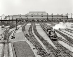 Washington, D.C., circa 1908-1910. "Switch yards, Union Station." 8x10 inch dry plate glass negative, Detroit Publishing Company. View full size.
Not Much Has ChangedWith the exception of the steam locomotives and the Pullman coaches the photo looks like it could be taken any decade within the past one-hundred years.
A wondrous journeyI just wanted to express my thanks for having experienced your wonderful website. I have been looking at the photographs, almost on a daily basis, for several weeks now. I am on page 634 and feel sad that my journey is about to end ... except for the new daily entries. I love photography and to able to learn about the photographer, the setting and people in them, and so much more, has been a life-changing experience.  Thanks you so much for enriching my life with these marvelous photos.
[You have 287 more pages to go, if you haven't checked out the 1,000 or so user-submitted photos. - Dave]
Washington Terminal Co.Union Station, which opened in 1907, was owned and operated by the Washington Terminal Co., a joint venture of the Baltimore &amp; Ohio and the Pennsylvania railroads.  My grandfather, a stonemason, came to Washington in the early part of the last century to work on the station and for the next 30 years worked for Washington Terminal in its Maintenance of Way department.
Hide and SeekThat's the statue on the very top of the Capitol dome appearing to sit on top of the curved roof of the Station.  It's actually about a quarter of a mile behind it.
Shoving to a jointThe little teapot switch engine (second engine from the left) looks like it is gently rolling to a coupling joint adding a baggage car and a coach (dining car with side door?) to a passenger consist. The fireman ("tallow pot") is leaning out of the window to pass signals to the hoghead from the man (men) riding point. They are working on that side because of the curve in the track. I think they are adding cars rather than taking them away because there is minimum smoke issuing from the switcher. What a pleasure it is to see old railroad photos like this on Shorpy. Many thanks for all the work you do to bring them to us.
Red LightTough place to get into.  I don't see one semaphore that's not in the stop position.
Train Now LeavingTrain now leaving on Track 5 for Anaheim, Azusa and CUC ... amonga!!
It&#039;s so clean and pristineIt's so clean and pristine that I thought it was another shot of Swartzell's model railroad.
One thing has definitely changedThat is the squeakiest clean ballast I have ever seen. Hundreds of locomotives and trainmen were waiting for the chance to drop grease, cinders, coal, spikes, tie plates, and whatever else would drip or come loose.
Clean sceneIs this not the tidiest industrial area ever? And that switcher with the ladderback tender is a modeler's dream.
In scaleBest model train layout ever!
The CameraAny idea what kind of camera/equip. was this picture taken with? it seems so remarkably clear!
[Standard 8x10 view camera. - Dave]
Split couplersIf you will look closely, you will see that most, if not all, of the locomotives have a slot in the coupler knuckle.  This allowed the use of link and pin coupling so either the locos are quite old or else they have to handle some older equipment still equipped with link and pin.  I would have thought that most every loco and car would have had patent Janney automatic couplers at this late date. The exception to this would be industrial or lumber company equipment where the combination couplers were common.
(The Gallery, D.C., DPC, Railroads)