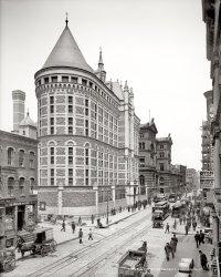 Circa 1905. "Tombs Prison, New York." The view down Centre Street at Leonard Street. What I wouldn't give for five minutes inside Cosmopolitan Incandescent Supply Co. ("Headquarters for Gas Lamps"), or A. Epstein Novelties &amp; Games! 8x10 inch dry plate glass negative, Detroit Publishing Company. View full size.
Covered domesMust be several hundred men visible in this photo and not one without a hat of some kind.  
LoiteringAre there a few folks waiting for relatives to be released at the front gate?
Sorry - CorrectionThat was the "regular 15 cent dinner" (not 50 Cent, who became a rapper).  Thank you.  I guess 15 cents was the poor man's rapper.
[Shorpy Tip-O-the-Day: If you were signed in as a registered user, you could edit your comments at any time! - Dave]
Cable CarsI didn't know New York had them.  Wonder if they had recently replaced street cars, former tracks for which are in the street where bricklayers are working.
[These are not cable cars. Electrically powered streetcars, underground power supply. - Dave]
IncandescentTen years or so ago, my father offered to help an upstate NY neighbour, a sort of quasi-Mennonite farmer, find a replacement part for his old gas stove. An old, old gas stove.
My dad, visiting a college friend who still lives in Greenwich Village,  looked up a hardware place in the yellow pages that sounded like it might help. They took the train out to Queens or Brooklyn or whatever. It turned out to be a cavernous, gloomy, warehouse of a place, run by a gnomish old guy. My father showed him the broken cast iron part.
The guy looked at it, shouted "Hey, Merl, bring up a Flamemaster Eight Doohicky Support Flange!"
And another gnomish old guy brought out the exact part.
I figure that place started out like the Cosmopolitan Incandescent Supply Co.
What a revelationI've heard of 'The Tombs' prison mentioned numerous times in various forms of media and always had a mental image of it being situated on an isolated piece of land far away from populated areas. It is interesting to see that it is located within the city.
Yes, we have no bananasexcept for these on the cart in the lower right.  I also plan to buy that "Regular 15 cent Dinner."  Looks like today is bargain day on the Lower East Side.
Dave&#039;s Time Machine Trip Dave, don't go to the stores, pick up a copy of the New York Daily News from that wagon out front of the incandescent supply store and put all that money you were going to spend into the stock market!  (just make sure to set the time machine before 1929 when you go to collect).
Old ShopsMy friend's father owned a hardware store on the Lower East Side. The business was founded by his grandfather in the 1920s. Talk about 5 minutes in a store, I wish I could go there again. I remember him telling me about a customer coming in, in the 1980s, and buying 10 boxes of nails and screws. Then he asked my friend's father if he wanted the contents of the boxes back. It seems he didn't want the nails and screws, but only the containers. They were of value to him because of the NRA emblems printed on them.
Tomb it may concern:Like Madison Square Garden, the name "The Tombs" has applied to a succession of buildings. Shown here is the second building (1902) to carry the name; the original (1838) was styled after an Egyptian mausoleum hence the name, which seems to be just too good to retire with the building.  
Another 5-minute IdeaWhat I wouldn't give for 5 minutes of sitting on that street corner (head covered, of course) and watching that scene unfold.  Preferably with a digital video camera.
(The Gallery, DPC, NYC, Streetcars)
