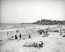 Nantasket Beach, Massachusetts, circa 1905. "Atlantic House and surf bathers." 8x10 inch glass negative, Detroit Publishing Company. View full size.
I love the beach scenes butAll I can think of is the uncomfortable ride home with sand in my bathing suits. I can't imagine the level of discomfort these people felt. I do love seeing people relaxing and enjoying themselves though.
Great HotelI know nothing about the hotel resort on the hill but if it's like any of the other hotels we've seen pictures on Shorpy of, I can guess it was probably destroyed in a fiery disaster. 
Surf NantasketFifty or so years after this photo was taken, Boston's iconic DJ Arnie Ginsburg would be hosting record hops at the Surf Nantasket. Arnie's now retired to the coast of Maine. Boston folks still remember Arnie at the Surf Nantasket.
Atlantic HouseThe name of the hotel is in the caption -- Atlantic House.  And yes, it burned to the ground, in January 1927.  It was built in 1877 by John Damon and later enlarged to about 175 rooms. Most of the site is now occupied by the Atlantic Hill Condominiums.
Looks Like SandDefinitely sand on the left.  Possibly Easter Sunday.
1879 EngravingAtlantic House on the left. Click to enlarge.

Skinny Dipper!Well, can't tell for sure; maybe that kid has on shorts, but considering the usual attire of the period, even that'd be pretty darn skinny!
[He is shockingly shirtless. Avert your gaze, ladies. - Dave]
My New WallpaperI think this might be my favorite beach shot to date.  There's so much to love.  The grand hotel, the beach houses, the Edwardian attire, the couple holding hands in the surf, the little kids wading.
Great Hotel DestroyedIn the late 19th century, The Atlantic House was the most famous summer hotel in New England due to its many  and varied notable guests.  Sarah Bernhardt, Wallis Simpson, President William McKinley and opera star Enrico Caruso, who gave two performances here, all enjoyed the fine accommodations the Atlantic House offered. Conveniences for guests included stairs directly to the beach and bath houses directly on the beach. The 175 room hotel burned to the ground during a blizzard on January 7, 1927.
I was just at this beachI was just at this beach last weekend. Aside from the attire and the buildings, it looks much the same. It's known for its dramatic variation between high and low tides. At low tide (depicted here) the beach is at least a quarter-mile wide; at high tide everyone is crowded up against the seawall just beyond the right edge of the frame here. On the other side of that (and the main road) would have been the famous Paragon Park.
Sea Bathing Absolutely Safe


How to See Boston: A Trustworthy Guide Book, 1895. 


Boston Harbor

Nantasket Beach is reached from Hull by the steamboat crossing Hingham Bay and ascending the serpentine Weir River; or by a railway, running along the sea-bounds. It is a fine expanse of gray sand, several miles long, between the ocean and the harbor, beaten by a light surf, and affording opportunity for safe bathing. Above the high-tide line are groups of hotels, restaurants, chowder-houses, and bathing-houses, where Anglo-Saxon-Celtic-Latin-Slav Boston sends tens of thousands of her citizens on torrid summer days. It is a grand place for "a good time" in a democratic way.



United States Investor, June 28, 1913. 


Atlantic House
Nantasket Beach, Mass.
One Hour from Boston by Boat or Train.
Rates: $5 per day and upwards
One Hundred Feet Above Sea Level.
Sea Bathing Absolutely Safe.
Address Linfield D. Damon, Manager


CanoeWonder how the canoe would handle the small surf? Interesting choice of seaside watercraft.
The Shorpy Curse!Another Grand Building destroyed by fire!
(The Gallery, DPC, Swimming)