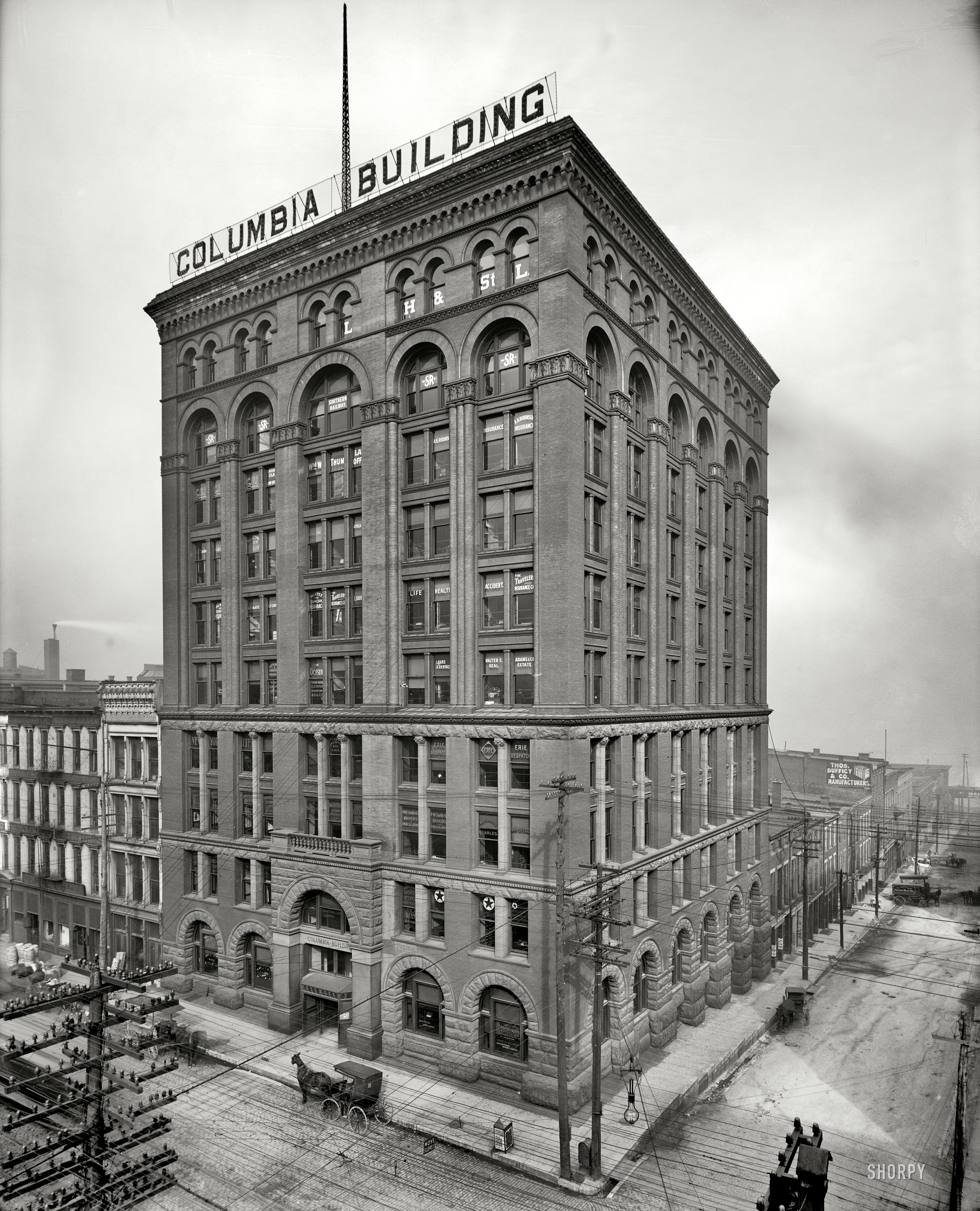 Louisville, Kentucky, circa 1906. "Columbia Building, Fourth and Main." An interesting look at the gritty environment of the urban horse. And maybe a record for the number of insulators on one tree in a Shorpy photo. View full size.