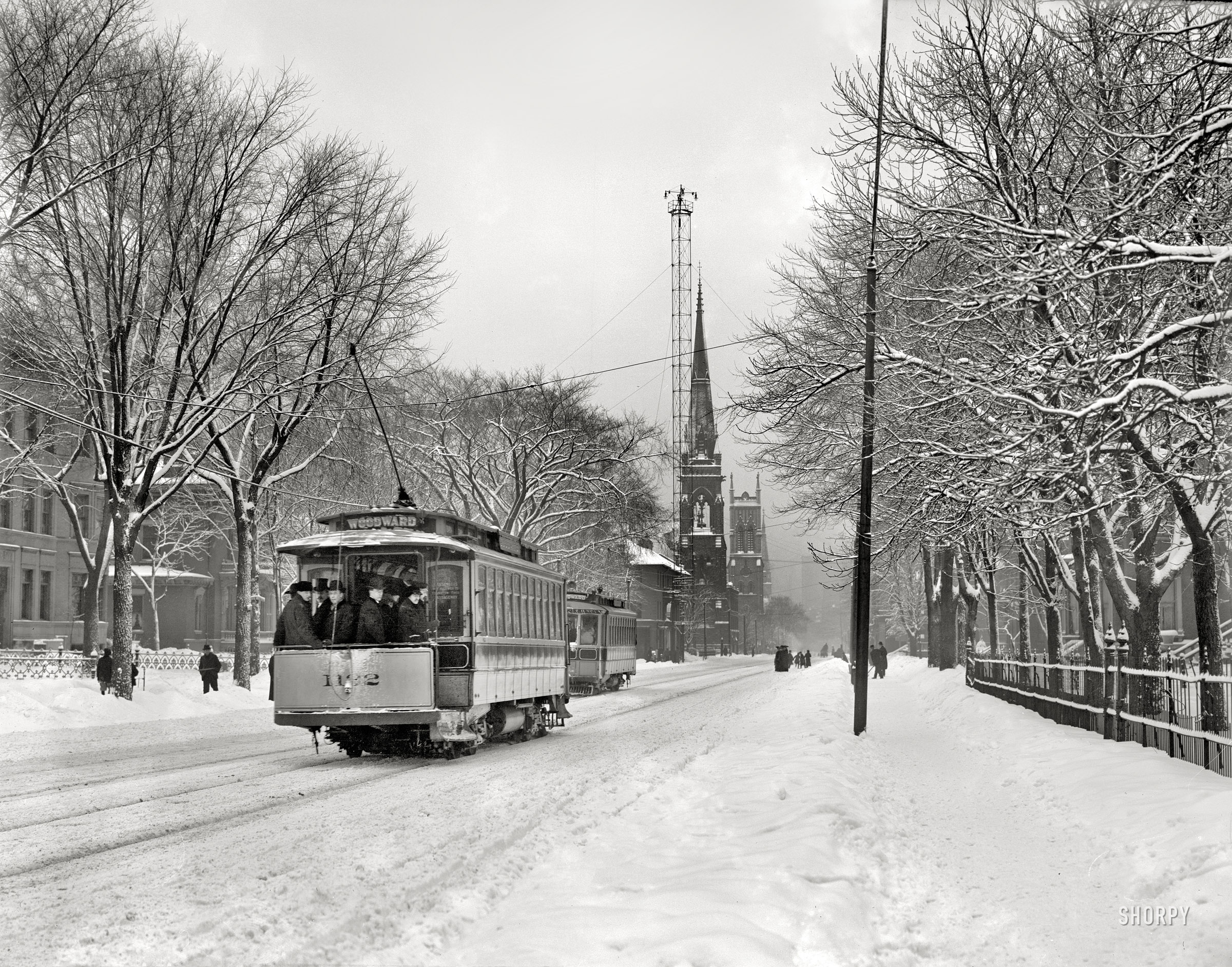 Detroit, Michigan, circa 1910. "Woodward Avenue in winter attire." Rising in front of the church is one of the city's arc-lamp "moonlight towers." View full size.