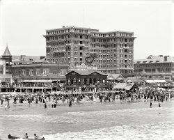 Atlantic City, New Jersey, circa 1913. "Chalfonte Hotel." 8x10 inch dry plate glass negative, Detroit Publishing Company. View full size.
Duntley PneumaticThere are the ubiquitous Salt Water Taffy, and the familiar Welch's Grape Juice, but I had to look up the Duntley Pneumatic Cleaner.
This thing makes the old Kirby Classic we had look like a featherweight!
Today&#039;s beachwearA couple of days ago, I saw several topless women sunbathing on Miami Beach. Topless women is a common sight on the beach there. I am curious what the people in this 1913 beach scene would think about what I saw on Miami Beach and I did not give it a second thought.
Pregnant woman at the beach.There appears to be a young woman "in a family way" standing at the edge of the surf with her hands behind her back.  I do not recall seeing another expecting mother in a beach crowd from Shorpy's turn of the century archives.
[That's a man, and probably not preggers. - Dave]
Corsets optionalAll over the world "clothing optional" beaches are gaining in popularity and people are willing to put it all out there in little or nothing.  I marvel at the huge quantity of clothing most of these people wore to the beach including hats, coats, jackets, umbrellas, boots, belts, corsets, etc. and here we are one hundred years later wondering "what were they thinking?"  If they could come back and judge us in speedos and thongs, what do you think they would say?
Must be a disposable.I've lived near the Atlantic my whole life and I'm not sure I've ever seen anybody canoeing it. 
Corsets, etc.If they could come back and judge us in speedos and thongs, what do you think they would say?
I suspect they would envy us our lack of scratchy and heavy bathing wear, as well appreciate the invention of sunblock, flip flops and beach towels.
ChalfonteHuh -- my family is from Chalfont, Pennsylvania.
I had a friend years ago who said it sounded like one of those diseases people don't catch anymore.
Pre-CoppertoneThe clothing in these old beach pics reminds us that a deep tan was not always cool. At the turn of the century only  common laborers had a tan, and true ladies and gentlemen avoided said tan at all cost. Of course I'm not telling you Shorpters anything you don't already know. That's why you're Shorpsters. 
Aunt KateMy great-aunt Kate Devon worked at the Chalfonte in the very early 1900s as a maid. Later as a manager of the linen closet operation. She also did calligraphy for fancy weddings and dinners that were held there.  She apparently made good wages or otherwise got tips or other favors, as she vacationed in Florida during the winter.
WaxworksMy mom took my sisters and myself to the Chalfonte in August 1971.  It was still very elegant but one got the sense that time had already passed the place by.  My strongest memory is one of the old matrons that spent her summer at the Chalfonte expressing her displeasure that my mom was taking us kids out to the amusements after 8 pm!
(The Gallery, Atlantic City, DPC, Swimming)