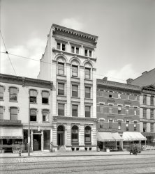 Utica, New York, circa 1910. "United Commercial Travelers of America building." On a block offering a cornucopia of goods and services: Dog Cakes (not to be confused with Twentieth Century Lunch three doors down), dog collars, bananas, cigars, an amusement arcade (the Shooting Gallery), coal, shoes, trunks and, finally, crockery and glassware. 8x10 inch glass negative View full size.