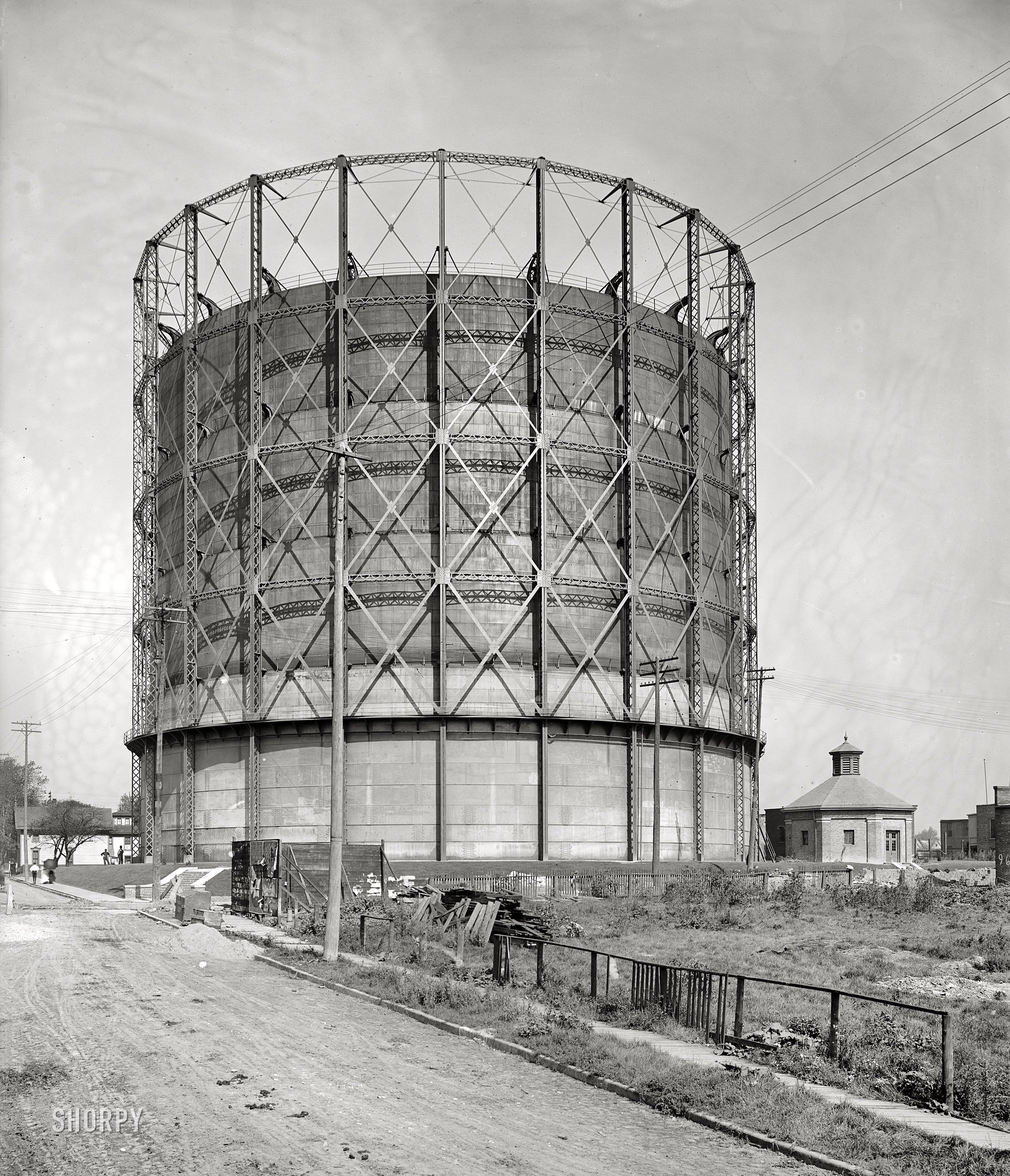 Circa 1905. "Gas holder, Detroit City Gas Company." A familiar sight from the era of "city gas," when municipalities had their own gas plants in the days before long-distance transmission of natural gas. The telescoping sections rose or fell as "illuminating gas," which was made by heating coal, was put into or removed from the holder. 8x10 glass negative. View full size.