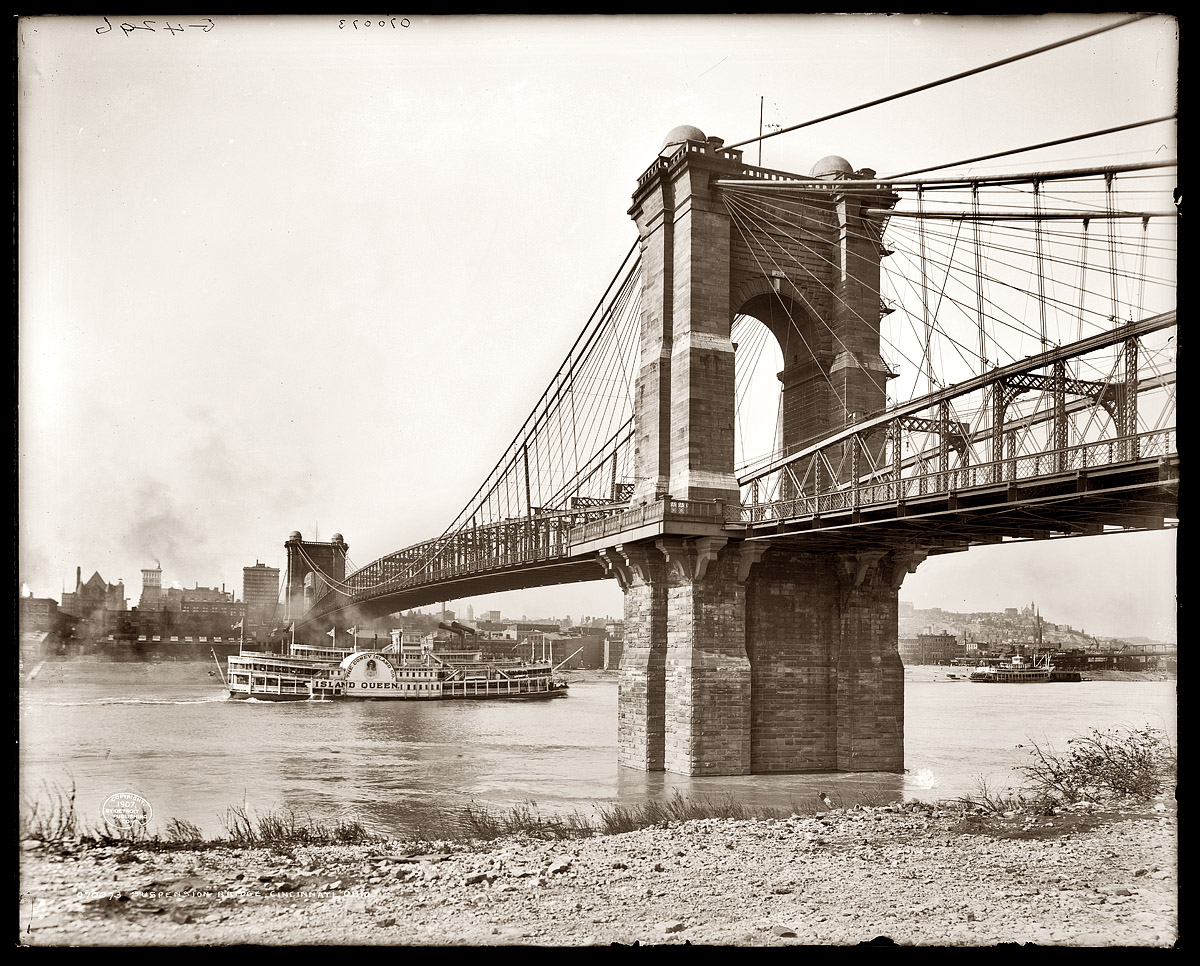 The Coney Island Co. side-wheeler Island Queen passing beneath the Roebling Suspension Bridge on the Ohio River between Covington, Kentucky, and Cincinnati in 1907. View full size. Detroit Publishing Co.