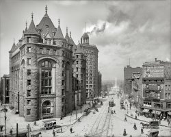 Bustling Buffalo, New York, circa 1908. "Erie County Savings Bank, Niagara Street." Another view of the imposing edifice previously seen here. 8x10 inch dry plate glass negative, Detroit Publishing Company. View full size.
I don&#039;t know, but --I think buildings can be both hideous and delightful, at the same time.
Harry Potter&#039;s other school?I swear this looks like it should be a school of magic!  What a GREAT building!
The entire scene is cool.  I love all of the business names painted on the windows and the detailing.  The spires are simply amazing.
Fare to Niagara and backFifty cents roundtrip! Last time I went to Niagara from Buffalo my niggardly tip was $20. I forget the fare. Inflation has come a long, long way.
What were the Yellow Cars?
With a name like Hazard . . . This time, Frank Williams has an officemate -- Willet E. Hazard. Corporate attorney Hazard and his brothers would incorporate a gasoline motor manufacturing company in 1909.  First named Hazard Engineering Co., it would soon become Hazard Motor Manufacturing Co. The slogan in a 1912 ad in "The Rudder," a yachting magazine, claims "The 'HAZARD' is distinctly better." That is the last mention of the company to be found.  Wonder why? 
Awesome!That's a great shot! I love the whole scene. The building is intense, why don't they make them like that anymore?
What in the worldAre those little square things under the Swift's billboard?
[An electric sign. Just wait till dark! - Dave]
Looks like rainI count at least five gents carrying umbrellas.
Erie Bank - This Is Your Lifehttp://www.buffaloah.com/h/eriebank/index.html
I&#039;m just one guyBut that hideous thing looks like a Kremlin prison to me.
A Shorpy stapleThe last charabanc we saw was here. A kind of open-air omnibus.
Death by BuffaloMark Twain once said, "To commit suicide in Buffalo is redundant."
Or words to that effect. But it looks full of life to me! Love the long street view, and all the wonderful signage.
The obelisk next doorAnyone know what the white monument is for down the street?
Seven LampsWhen the term "architecture" is used, this is the type of structure they are referring too.  Anything else is just another building.
&quot;To commit suicide in Buffalo is redundant&quot;That was a quip by Neil Simon, used in "A Chorus Line."
OmnibusesJust checked out the previous photo of the same bank. There are two omnibuses in front, one like that seen in this pic (probably electric; right-hand drive, too) and the other, just nosing into the lower left corner, is definitely gasoline-powered if that hood is any indicator. So I guess these things were pretty common. 
Imagine Winter!This same scene would be filled with Horse Drawn Sleighs...what a fun way to get around!
No WordsI don't know what to say other than that is one of the most beautiful buildings I have seen on Shorpy. The thought of the wrecking ball plowing through those gorgeous granite walls makes me want to cry like a baby.
Charabancs!Here's why I love this site. I never heard of a "charabanc" until Shorpy. I just thought they were funny little buses. You can read all about it at http://en.wikipedia.org/wiki/Charabanc
The obeliskis the McKinley Monument in Niagara Square.
Pay your dimeand climb up to the top of the tower and choke to death on the emissions of that nearby smokestack. A testimony to the air quality of the time is that the upper floors of all the buildings are blackened with soot.
It&#039;s an electric signProbably a static illuminated letter board, vs. the Times Square style "crawl" which I think was beyond the technology of the day (though not TOO far beyond).
The bulbs aren't really bright enough to work well in daylight.
The message may have changed nightly, each letter was controlled by a large rotary wafer switch housed in a wooden box, that when turned would cause the bulbs in the sign to display a different letter at each position.
High technology, 1908 style. 
Shorpy, keep these images coming, I love poring over them. America near its peak as the industrial power of the world, with no end in sight. The age of coal, steam and steel.
Weird coatThere's a man on the right side of the street, to the left of the cigar store awning, his back to the camera. What are all those white things hanging off the back of his coat? And is he holding a banjo in his right hand?
[Those are scratches and blotches in the emulsion. - Dave]
Nothing remainsEssentially everything in this image except the McKinley Monument was destroyed in "urban renewal" in the 1960s.  The site of the bank now appears to be a boring late-Sixties state office building.  I can't find any trace of any other original building in this image.
There was a good story written in 1967 when the Erie County Savings Bank was demolished.
(The Gallery, Buffalo NY, DPC, Streetcars)