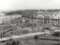 New York circa 1908. "Morningside Park and elevated line." Another view of the "L" seen here a few days ago. 8x10 inch glass negative. View full size.
The Block HouseThat's Central Park in the background there and the structure just left of center peeking up through the trees is the Block House. 
From Morningside Park to Central ParkAfter consulting the vast riches of the Shorpy archive, I have determined that this view was taken from the grounds of St. John the Divine, looking southeast across Morningside Park toward Cathedral Parkway (110th Street) and the north end of Central Park. The apartment buildings along Manhattan Avenue (at the left) are still there, except for the one closest to the L tracks. Of the three buildings on the other side of the tracks (south side of 110th St.), only the middle one has been replaced. Thanks, Dave, this has been loads of fun!
&quot;722 Miles&quot; -- recommendedIf anyone has access to a copy of the book "722 Miles: The Building of the Subways and How They Transformed New York." I think there is a picture of this curve when it was built out in farmers' fields.  The book is very good at explaining how the subways, elevated railways, and street cars made possible the development of a much larger city.
A more-recent (1896) view:
A different NYCOur history books would have us believe that New York City of this time, was a seething cauldron of oppressed masses from Eastern and Southern Europe.
Yet these photos show another, more gentile atmosphere of this urban giant.
I wonder if school teachers are aware of, and make use of this website?
[This being the Upper West Side, the atmosphere was probably only medium-Gentile. - Dave]
(The Gallery, DPC, NYC, Railroads)