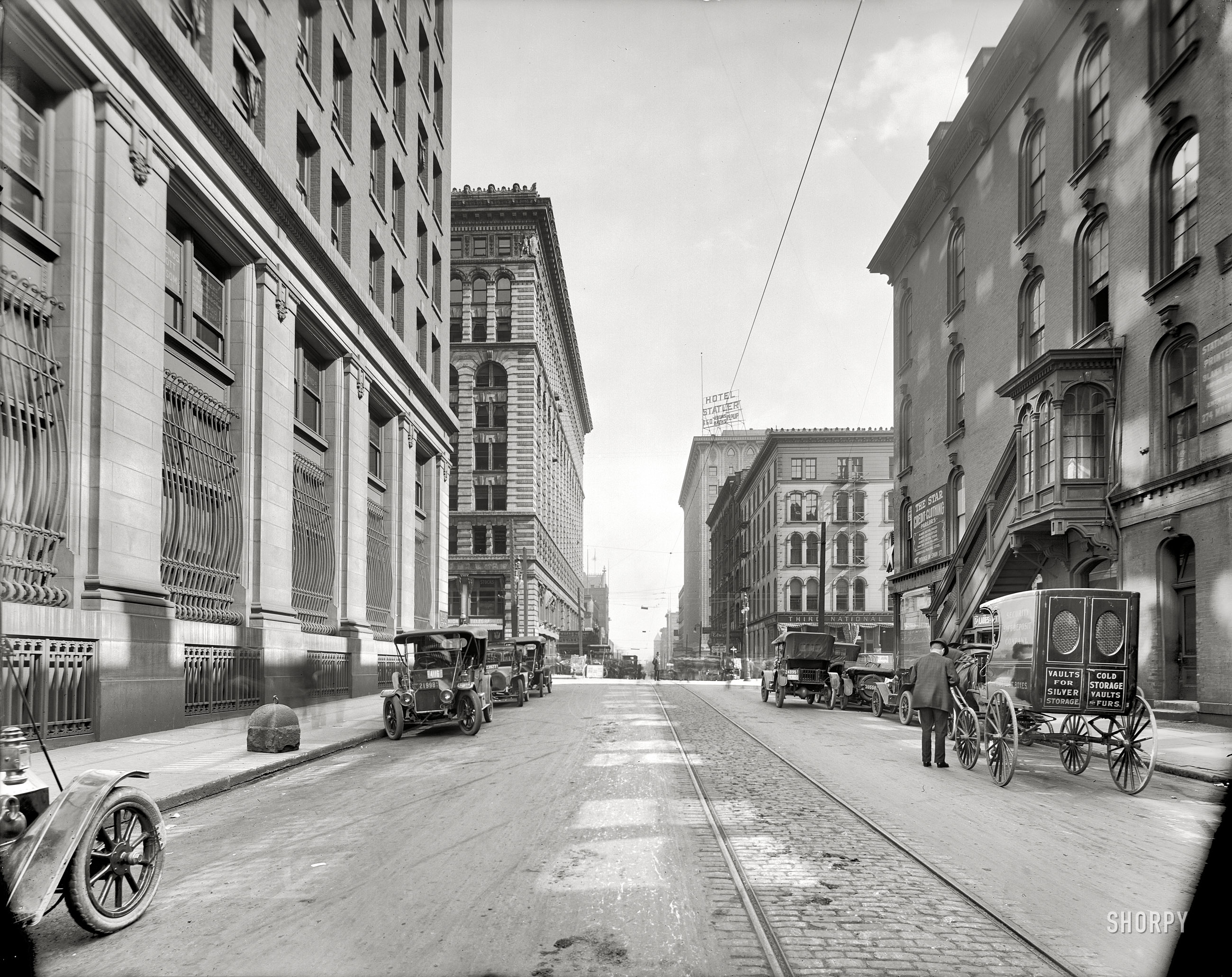 Buffalo, New York, circa 1911. "Swan Street." The motorcar gains a foothold where hooves once trod on Swan in Buffalo. 8x10 glass negative. View full size.