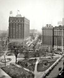 Detroit, Michigan, circa 1920. "Grand Circus Park, looking toward Washington Boulevard, and Hotels Statler and Tuller." 8x10 glass negative. View full size.
Arbuckle, perhapsIs that a theatre marquee in the lower right corner the reads FATTY? This would be about a year before the famous Fatty Arbuckle scandal.
re: ArbuckleLightening up that bit at the lower right does indeed point to the marquee reading both "Fatty Arbuckle" as well as "Talmadge." He worked with Natalie Talmadge in three short comedies 1917-1918.
[The Talmadge on the marquee is Constance. - Dave]
Motor CityThe motor car takeover is nearly complete - there are only two equine holdouts in view.
It&#039;s the Adams Theatre marqueeat lower right.  It was at 44 Adams Avenue West and opened in 1917 as a vaudeville house before switching to movies the following year.  After numerous renovations and direction changes, the Adams finally closed in 1988.  The Fine Arts Building it was in was demolished in 2009.
No Happy EndingsThe Tuller was demolished in 1992, and the Statler went down in 2005. Both had sat vacant for well over a decade. They were replaced by... well, nothing yet.   
Oh, and the theater in the foreground showing the Fatty Arbuckle movie? It is the then-new Adams (opened in 1917). It was torn down in 2009, except for its facade, which rather spookily stares down empty-eyed on the park across the street
Street level viewHere's a street level view of the Statler and Tuller from a different corner of Grand Circus Park:
https://www.shorpy.com/node/6736?size=_original
ShorpyvilleI have recently been inspired by photos posted here. I call my series "The twilight world of Shorpyville."
[Ooh. Intriguingly eerie! - Dave]
(The Gallery, Cars, Trucks, Buses, Detroit Photos, DPC)