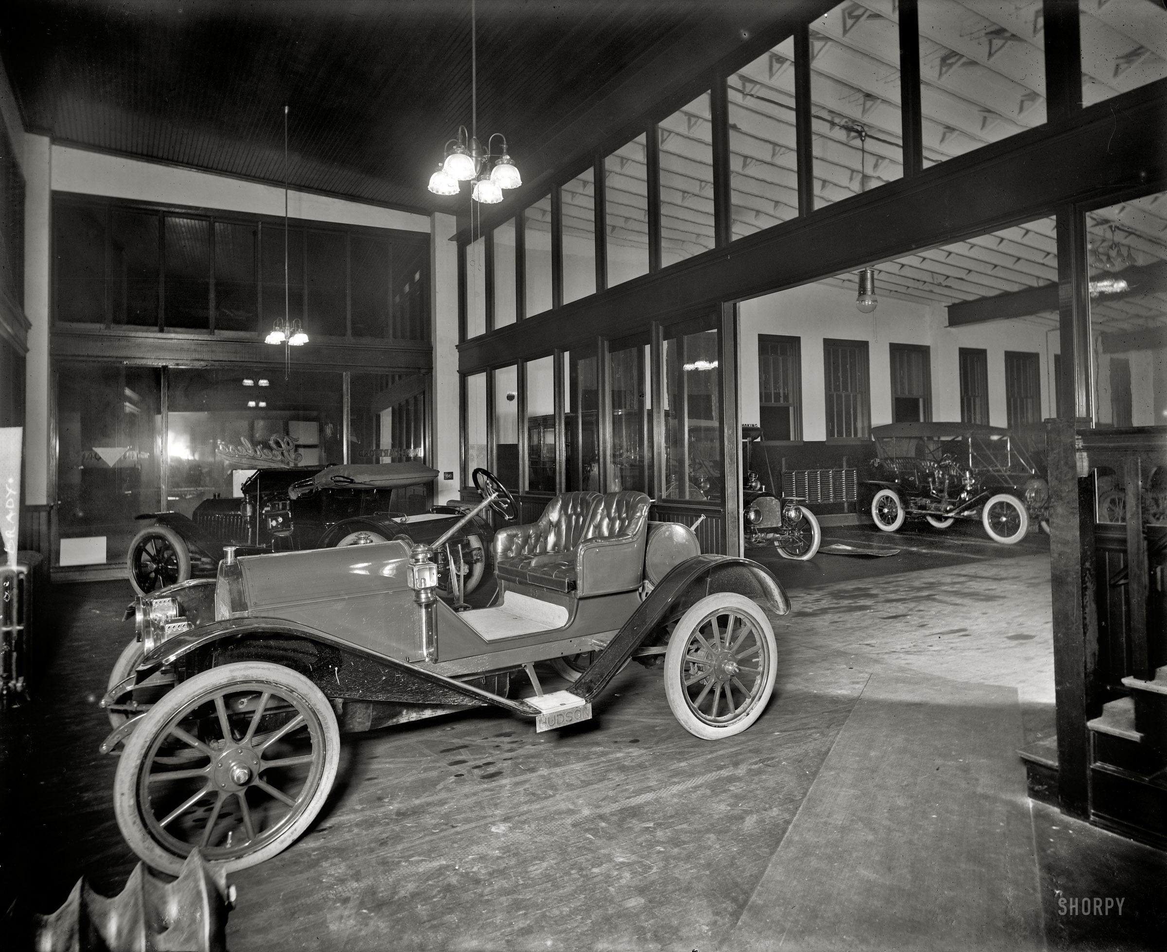 Detroit, Michigan, circa 1910. "Brady -- Gas Company. Auto showroom." Star billing goes to the gas light fixtures above a Hudson center stage at the showroom of J.H. Brady, dealer in Hudson, Peerless and Pope-Hartford automobiles. 8x10 inch dry plate glass negative, Detroit Publishing Company. View full size.