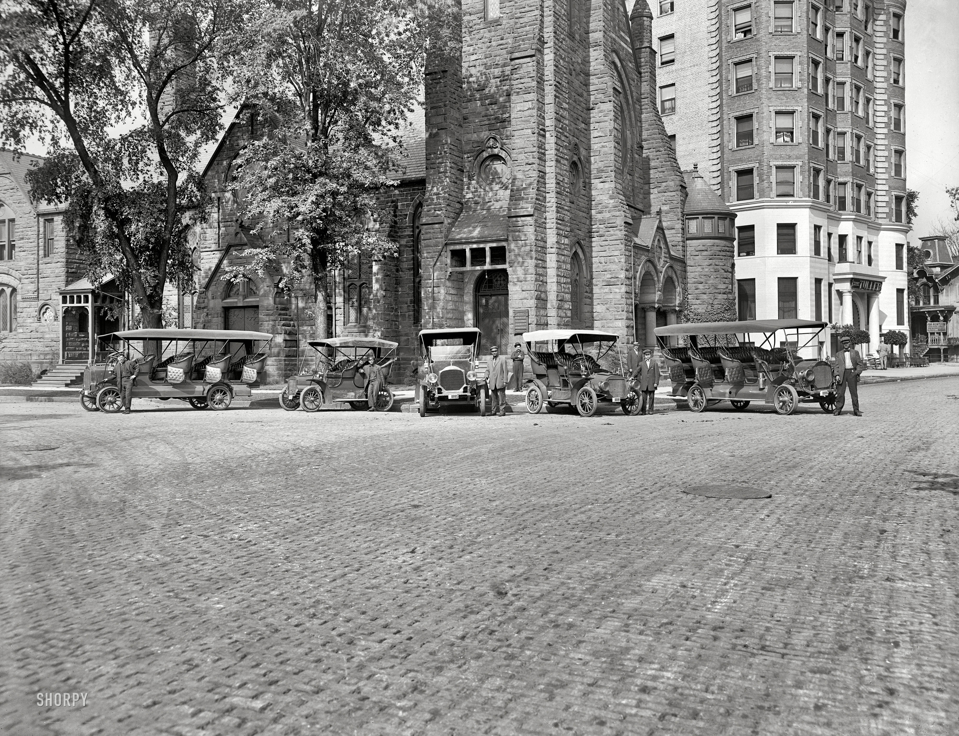 Detroit, Michigan, circa 1910. "Tourist Auto Co. (Tourist buses in front of church with Hotel Tuller at right)." Detroit Publishing glass negative. View full size.