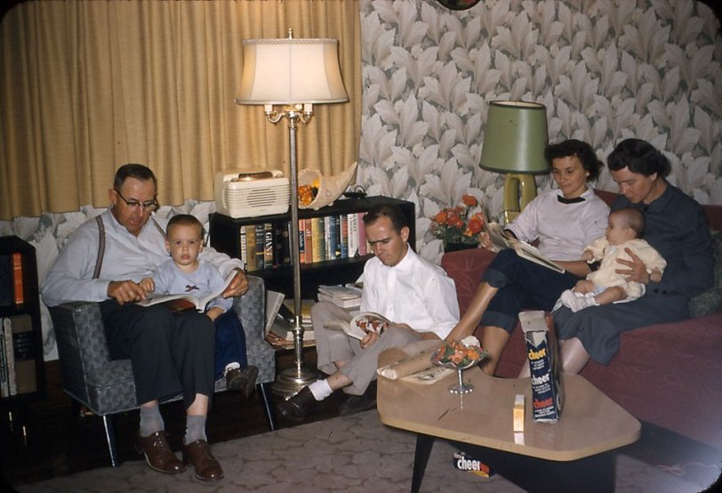 This was Clinton, Iowa, at our 3rd Street address, in 1956. I am seated in my Grandfather's lap, Dad is on the floor with a magazine, Mom is reading the paper and Grandmother is counting the hairs on George's head or has fallen asleep.
My ever-present New Blue Cheer boxes are also in evidence. I cannot understand why I was fascinated by soap boxes. Maybe I will get a 4 year old to explain it to me sometime. View full size.
