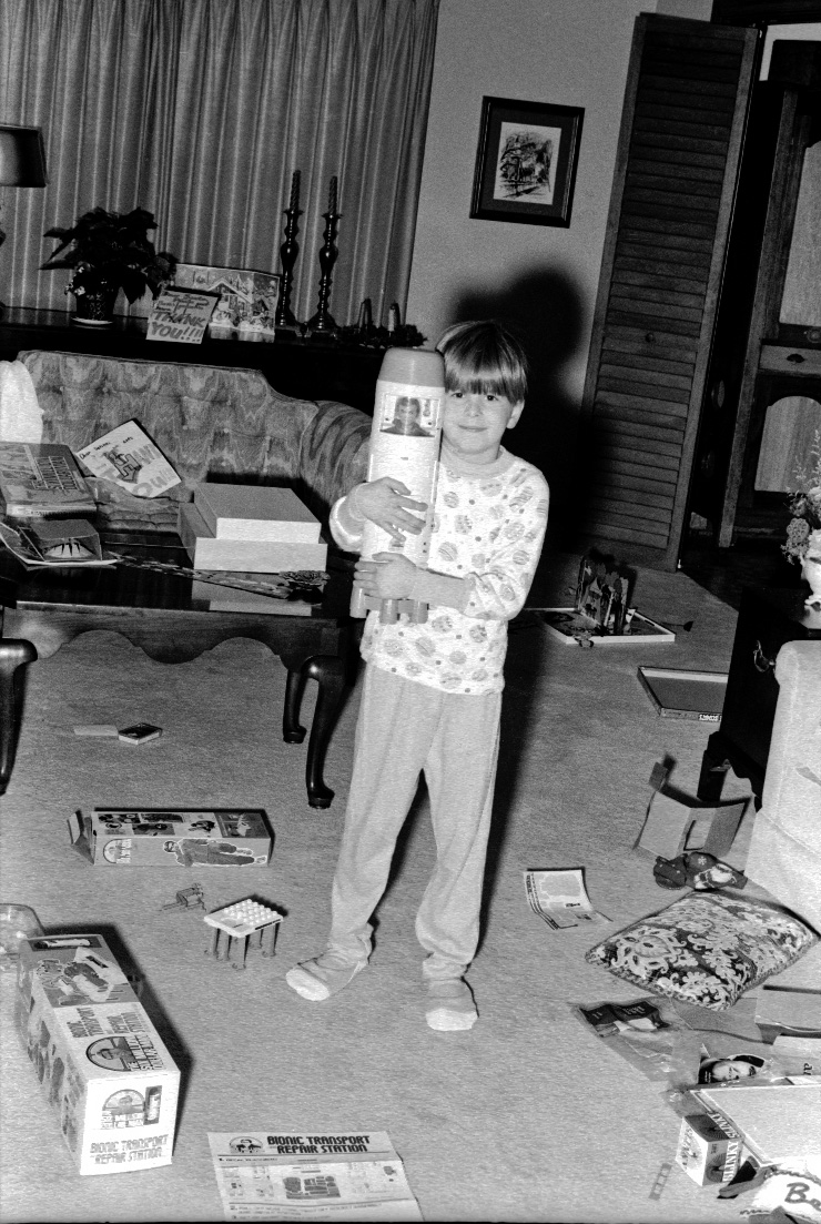 Indianapolis, 1977. My youngest Brother Jim had a $6 Million Dollar Christmas.  Here he has Steve Austin, the 6 Million Dollar Man, stored in the Bionic Transport and Repair Station.

I expected to embarrass him with this image at our family gathering this summer but instead I found Steve Austin and and his repair station in my niece's playroom! Jim had gotten these toys out of storage just months ago.

35mm B&W taken with my Yashica SLR and processed at home. View full size.