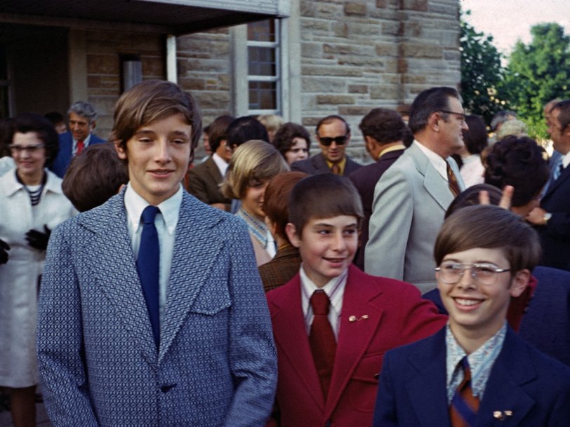 St. Matthew Elementary in Indianapolis, IN, 1972. Left to right: Bob Gardner, Bill Lawler, Bert Happel.
Here we've just exited from our graduation ceremony and we are enjoying ourselves while posing for family photos.  I had attended St. Matthew's for three years and I believe that Bill had been there two.  Bill and I are wearing our honor roll lapel pins.
While we had classmates who lived in our respective neighborhoods those neighborhoods were spread apart.  Consequently our friendship was mostly limited to school hours.  I recall being very happy to receive an invitation and to attend the subsequent graduation party at Bob's house.
We would go our separate ways the next fall attending three different, though local, high schools. I'd next run into Bob again when we were freshman at IU and living in the same dorm.
I don't know if I ever saw or spoke with Bill again.  He died in his early 40s from ALS (aka Lou Gehrig's).  I remember him being obsessed with cars and auto racing.  Before he died he did some racing and was involved with (owned?) a racing team as his health declined.
Original slide taken by my father using his Kuribayashi Petri rangefinder.  I digitized the slide and cleaned a lot of dirt off the image. View full size.
