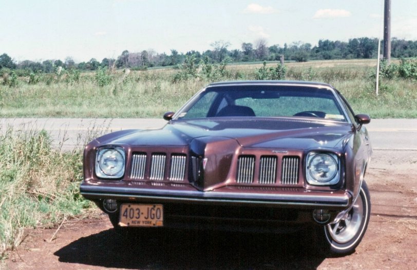 73 Grand Am. On Wellesley Island New York.1974.The nose of the car was made of soft rubbery stuff. The TV ads showed how you could crush it with a baseball bat and it would bounce back in shape. Unfortunately on its best day it only got 16 mpg highway. Kodakchrome 35mm slide. View full size.
