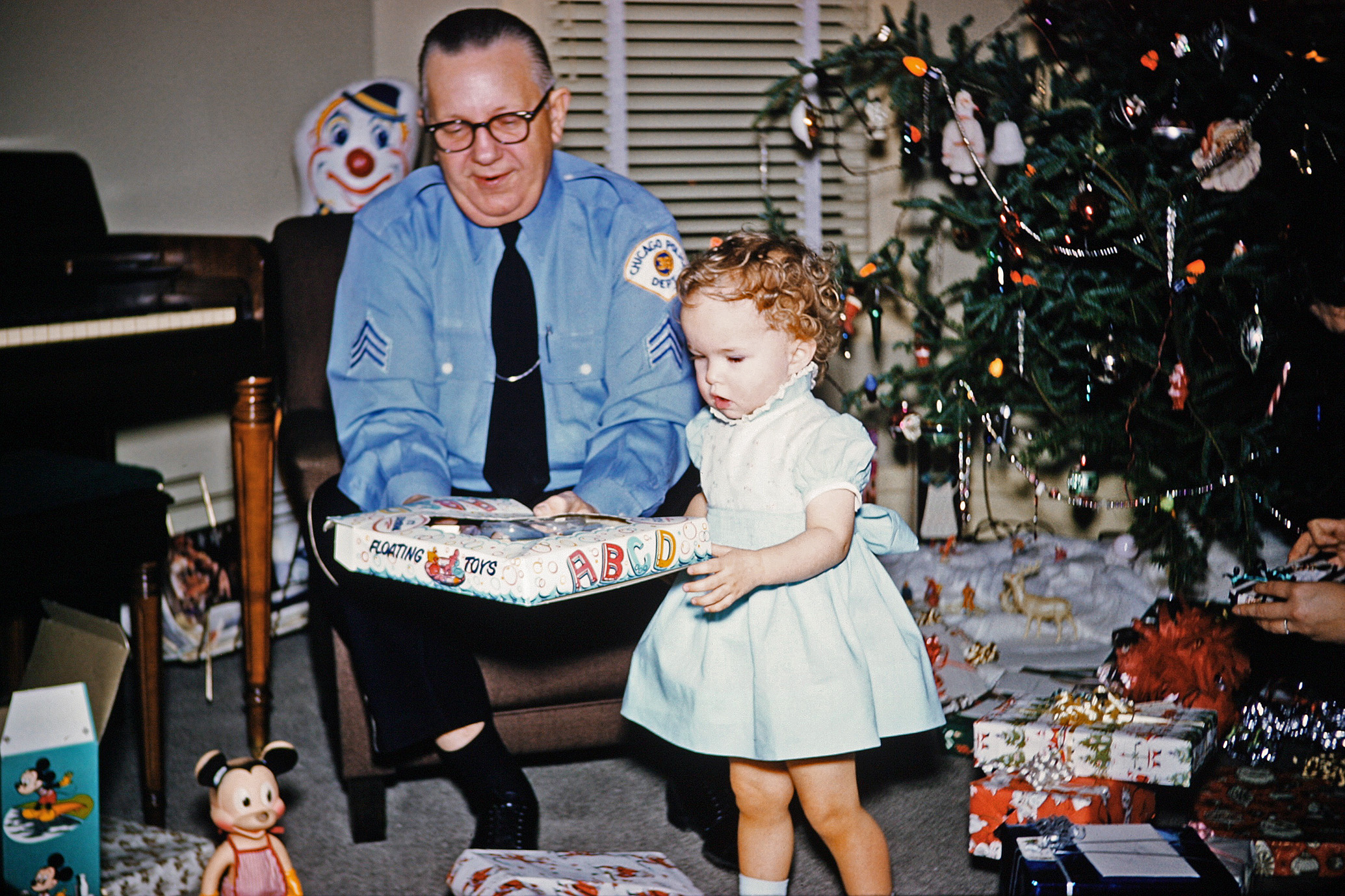 My mom, then just a toddler, opening presents with my great-grandfather at my great-grandparents' house on North Pulaski in Chicago. He was close to retirement as a sergeant with the Chicago Police Department when this was taken. He passed on prior to my memory, but Great-Grandma (or GG as we called her for short) continued to live here until dementia took her independence in the early 1990s. View full size.