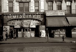 December 1937. Midcity Cinema at 1223 Ninth Street NW in Washington, D.C. View full size. 35mm nitrate negative by John Vachon for the FSA.
Confectionery adsLove the ads on the lower front of the store "Welcome Students  Get A Lift With A Camel".  
I had forgotten about the movie stills. Our local theater placed the big advertising poster in a display behind glass and had the movie stills in small frames all around it at one end of the lobby.  If I remember correctly, they were also in frames seen from the outside of the theater too.  All those beautiful brass fixtures, chandeliers hanging from the ceiling, crystal drop sconces on the walls that dimmed slowly as the movie started, velvet wallpaper, all gone now.
Sign in the WindowS.H. Dudley, Promoter and Producer.
King&#039;s Beauty ParlorKing's Beauty Parlor offers the Poro System of beauty treatment, which, though now mostly forgotten, was probably the most significant and socially important factor in the assertion of Afro-American women's self-esteem in the first half of the 20th century. See the Answers.com bio for Annie Turnbo Malone.
At the MoviesA rather curious mix of pictures at the Midcity. They're showing a double feature of two movies made five years apart. The main feature is "Easy Living" which was released on July 7, 1937. It starred Edward Arnold, Jean Arthur and a young Ray Milland, and was written by the great Preston Sturges. The second feature is the real puzzler. According to IMDB, Charles "Buck" Jones made "Hello Trouble" back in 1932. In fact it was release July 15th 1932 meaning it was a week shy of being exactly five years older than "Easy Living." Also visible but nowhere near as prominent is a poster for a serial "The Black Coin". Even it was newer than "Hello Trouble." having been released September 1, 1936. A line-up that would seem to indicate at best a second run house.
The cast of "The Black Coin" is sort of interesting. It included a couple of really major silent movie stars - comedian Snub Pollard and Clara Kimball Young - as well as the legendary stunt man and stunt coordinator Yakima Canutt. Canutt was the second unit director who directed the chariot race scene (among others) in the 1960 remake of "Ben Hur." Also in the cast were Dave O' Brien, who would go on to win an Emmy as a writer for Red Skelton, and Ruth Mix, the daughter of legendary cowboy star Tom Mix, in what would turn out to be her final movie.
As for Buck Jones, he is considered to be one of the greatest of the "B" movie western actors. He made 57 more movies in the ten years between "Hello Trouble" and his death in 1942 in Boston's Coconut Grove Fire (November 30, 1942).
Washington D.C.?Why was the Farm Security Administration taking photos in D.C.?  
I can understand that the govenment might need images of small town and rural American but this was just a few blocks away.  
Lobby stillsThose movie stills - which incidentally were almost always displayed in glass-fronted cases outside cinemas in the U.K. - were never actual prints taken from the movie footage. They were specially taken on-set by a studio stills photographer shooting with a 5 x 4 camera from more or less the movie camera position. As a result sometimes, though not often, they showed angles and even set-ups that didn’t appear in the movie itself.   
Midcity CinemaA chunk of ceiling and chandelier fell on audience in 1945: http://cinematreasures.org/theater/23359/
[Thank you. Now we know the address, which I added to the caption. - Dave]
Midcity CinemaThis location is now Washington Convention Center.
Mid City AddressTthe address of the Mid City was probably 1223 7th St.
During our research on the address of the Alamo, the most reliable source of info was the website about the Shaw District of Washington DC where the theaters were located:
http://planning.dc.gov/planning/lib/planning/preservation/brochures/hist...
This document mentions the address of the Mid City Theater twice on p. 14, including a reference to the theater's owner:
"As early as 1907, Shaw residents could enjoy a vaudeville act or be treated to the new technology of a moving picture show in their own neighborhood. The Happyland, Gem, Alamo, Mid-City, and Broadway Theaters were all built between 1907 and 1921 within five blocks of each other on 7th Street; the Raphael was two blocks over on 9th Street.
Of these, the Broadway and Mid-City were owned and operated by African Americans for the largely black patronage in Shaw by this time. In 1919, well-known vaudeville performer Sherman Dudley advertised his Mid-City as “the only theater on Seventh Street catering to colored people that does not discriminate.”
Colleen
(The Gallery, D.C., John Vachon, Movies)