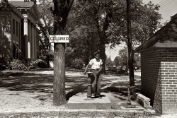 April 1938. "Drinking fountain on the county courthouse lawn." Halifax, North Carolina. View full size. 35mm nitrate negative by John Vachon for the FSA.
HalifaxThis has disappeared into history for most people, but I remember it quite vividly. We still had two water fountains and four toilets in North Carolina in the late 1950s.
Strange FruitThis image brought to mind the powerful lyrics of Strange Fruit, sung by Billie Holiday:
Southern trees bear strange fruit,
Blood on the leaves and blood at the root,
Black bodies swinging in the southern breeze,
Strange fruit hanging from the poplar trees.
Pastoral scene of the gallant south,
The bulging eyes and the twisted mouth,
Scent of magnolias, sweet and fresh,
Then the sudden smell of burning flesh.
Here is fruit for the crows to pluck,
For the rain to gather, for the wind to suck,
For the sun to rot, for the trees to drop,
Here is a strange and bitter crop.
Separate but equal?I wonder if there is a near identical drinking fountain on the opposite side of the lawn for whites.  This fountain is well made and mounted on a cement base.  Was this the former white fountain which has now been downgraded after the installation of a new cooled water fountain indoors?
[If it is, it wouldn't be very equal. - Dave]
RarelySeparate but equal was rarely equal.
Did you know you are a jerk Dave?Dave;
It is a good thing that we as Americans have moved away from the horse and buggy mindset of idiots like you
[Ms. Palin, perhaps you're a bit confused about who is posting what. Either that, or this is a dig at Sarah Palin? I think I get it. - Dave]
I rememberIn 1963 I went on a trip thru the Deep South with a neighborhood family to help watch the children I was 14 years old and had grown up in a segregrated small town in Ohio. I took my little Brownie camera with me.  For the first time I saw scenes like this as we traveled.  I came home a change person. I grew up alot that summer, when school began that fall I remember taking a stand in my history class for civil rights. I was no long the little girl from a small town in Ohio, I had witnessed the unequality of the Deep South. I was no longer a child. 
(The Gallery, John Vachon, Kids, Small Towns)