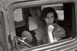 October 1938. Farm wife and baby waiting in the car while her husband attends the auction. Oskaloosa, Kansas. View full size. Photograph by John Vachon.