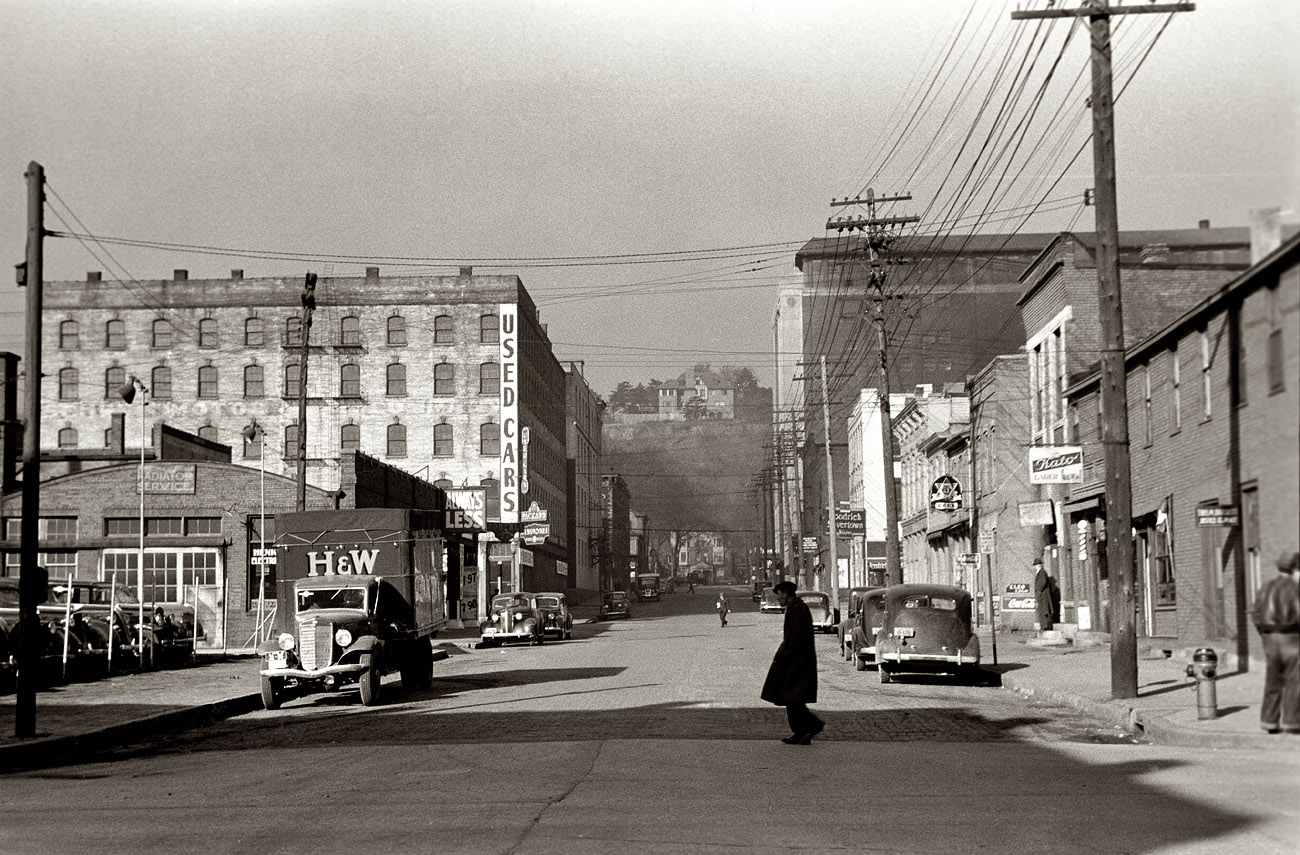April 1940. "Business section of Dubuque, Iowa. The rich live in houses on the cliffs seen in background." View full size. 35mm negative by John Vachon.