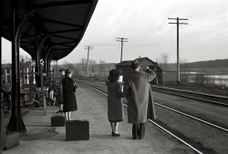 April 1940. East Dubuque, Illinois. "Waiting for the train to Minneapolis." 35mm negative by John Vachon for the Farm Security Administration. View full size.
WallpaperEvery week I choose a Shorpy photo to be my wallpaper.
This week, this will be.
WaitingYou know, it'd be nice if this railroad still had passengers.  It's only freight now.
1942Two years later, this stop would be packed with servicemen leaving for the great unknown, sobbing wives and girlfriends and staunch parents (Dad with his lip quivering, Mom dabbing her eyes with the hankie). Wow, so much changed in such a short time!
(The Gallery, John Vachon, Railroads)