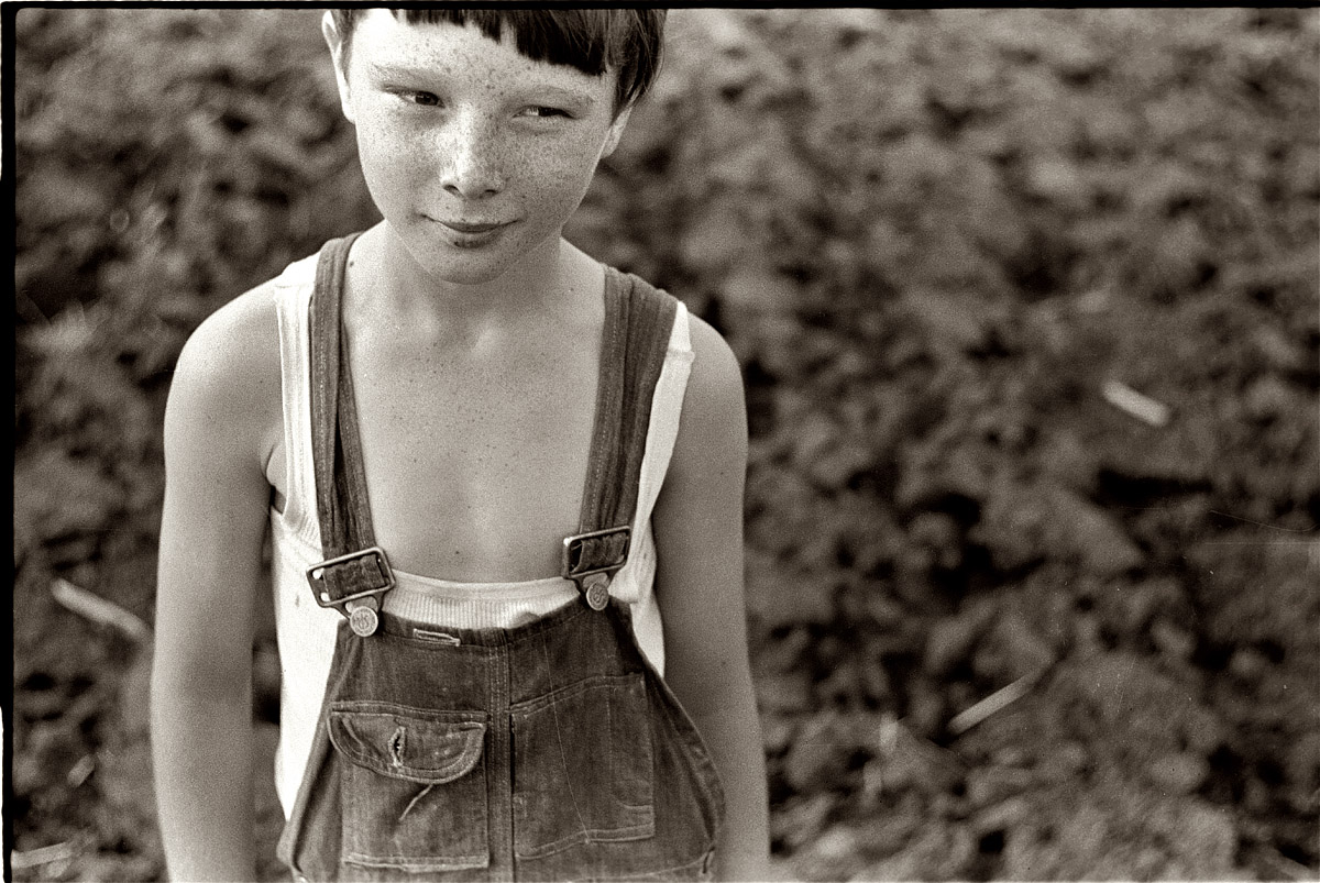 Freckles on his face, mischief in his eye: Another shot of the cute kid with the calf from May 1940 in Granger Homesteads, Iowa. View full size. 35mm nitrate negative by John Vachon for the Farm Security Administration. Who are you?