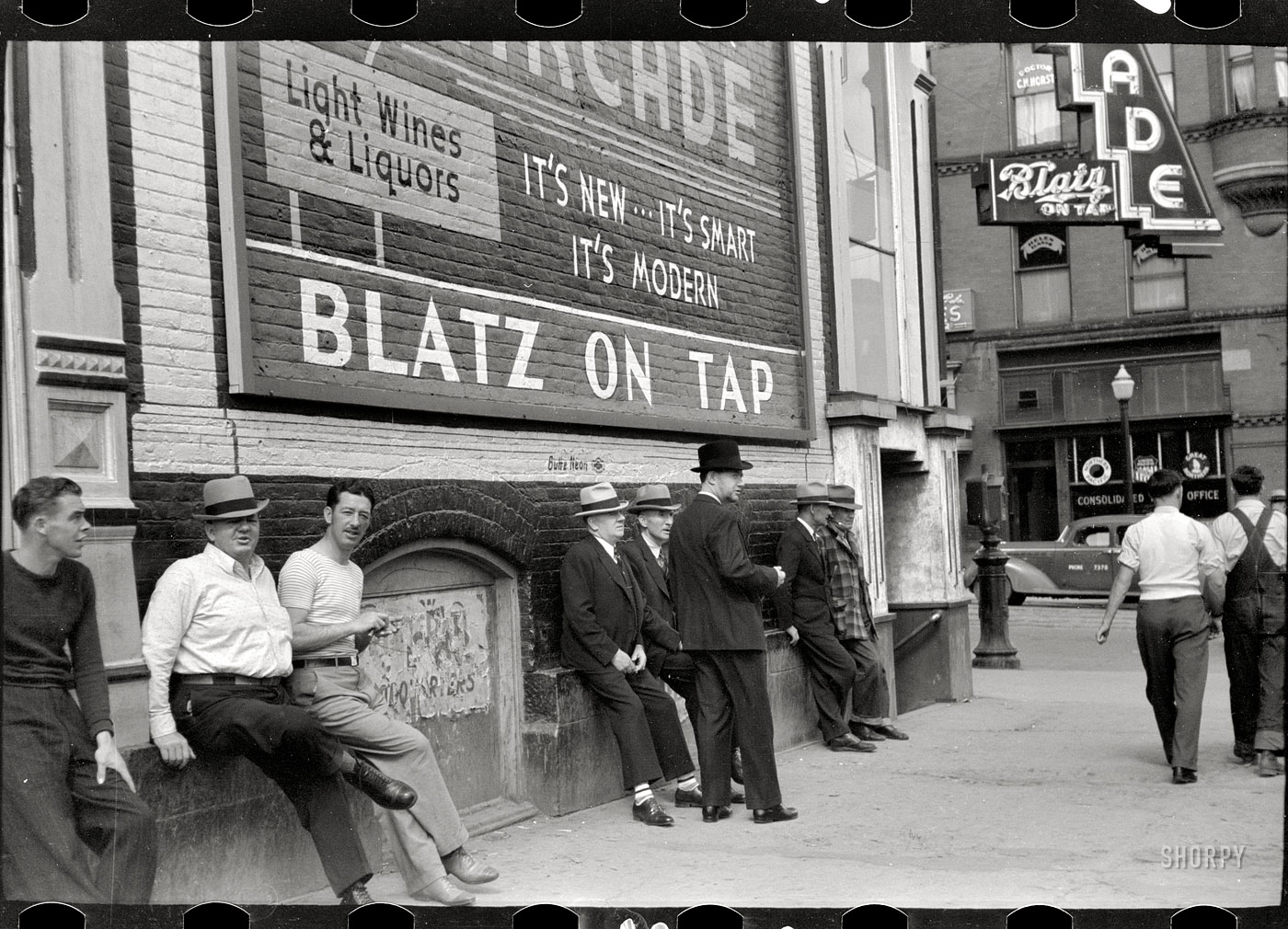 Summer 1939. Butte, Montana. "Men lounging in front of the Arcade." 35mm negative by Arthur Rothstein, Resettlement Administration. View full size. 