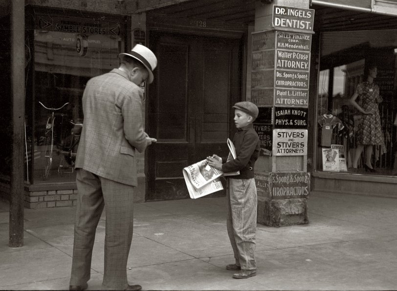 Photo of: Small Town News: 1939 -- October 1939. Newsboy in Montrose, Colorado. View full size. 35mm nitrate negative by Arthur Rothstein for the Farm Security Administration.