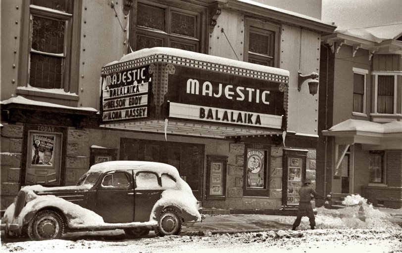 Photo of: Now Playing: 1940 -- February 1940. Shoveling snow away from the movie entrance in Chillicothe, Ohio. View full size. 35mm nitrate negative by Arthur Rothstein for the FSA.