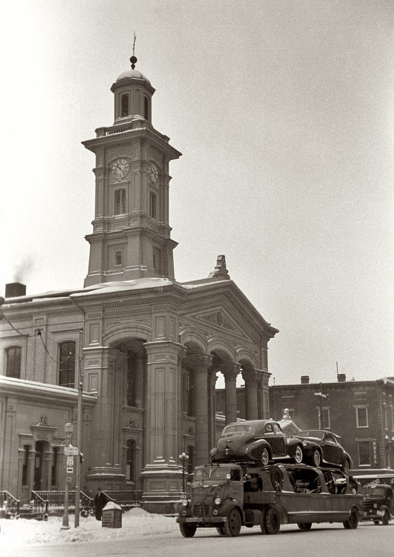 Photo of: Chillicothe Buicks: 1940 -- February 1940. Courthouse and auto transport hauling Buicks in Chillicothe, Ohio. View full size. 35mm nitrate negative by Arthur Rothstein for the FSA.