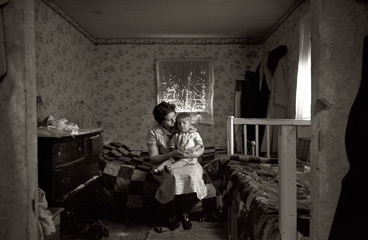 December 1936. Mother and child in the home of L.H. Nissen, hired man. He is married, has seven children, one grandchild, all living together in a three-room shack near Dickens, Iowa. View full size. 35mm nitrate negative by Russell Lee.