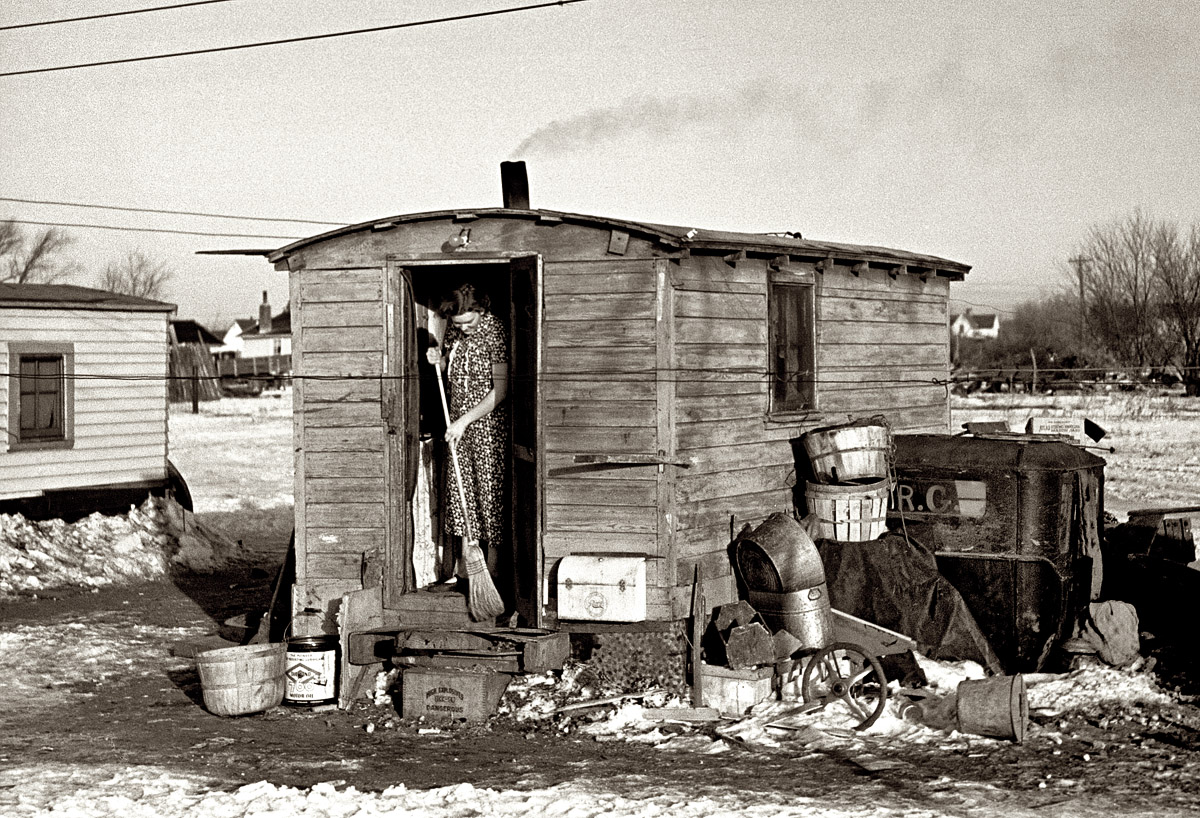 December 1936. "Mrs. Charles Benning sweeping steps of shack in Shantytown. Spencer, Iowa." Seen earlier here with her baby. View full size. 35mm nitrate negative by Russell Lee for the Resettlement Administration.