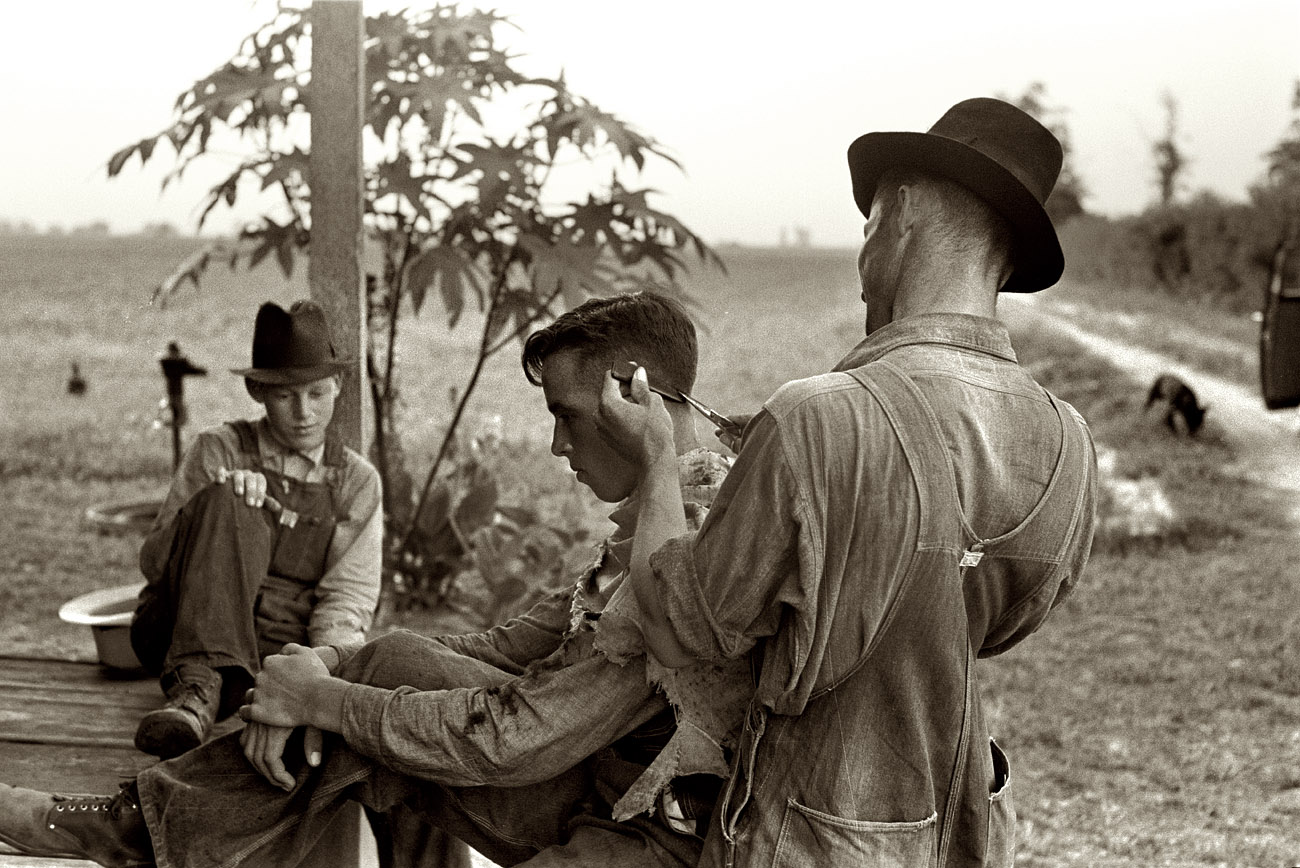 August 1938. "Farmer cutting his brother's hair. Caruthersville, Missouri." 35mm negative by Russell Lee for the Farm Security Administration. View full size.