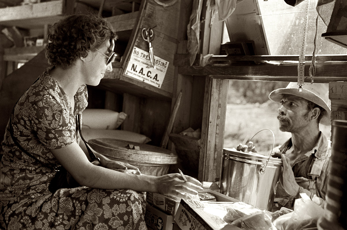 September 1938. "Making a purchase at traveling grocery store. Forrest City, Arkansas." View full size. 35mm nitrate negative by Russell Lee for the FSA.