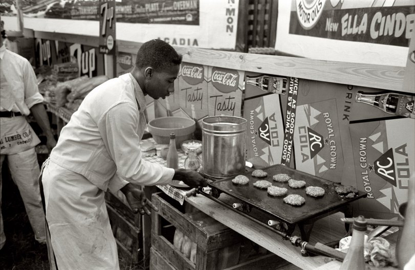 October 1938. "Making hamburgers in the concession stand at the National Rice Festival. Crowley, Louisiana." View full size. 35mm nitrate negative by Russell Lee for the Farm Security Administration. You want fries with that?

