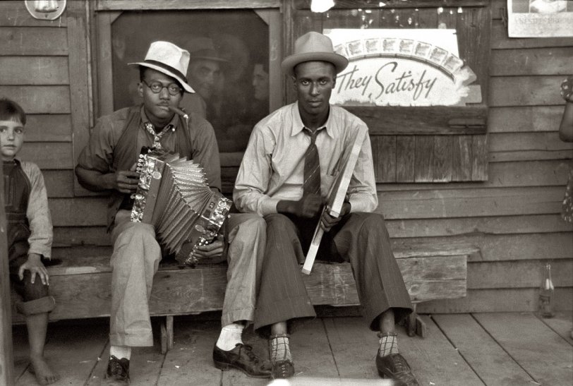 Photo of: Red Hot Chili Peppers: 1938 -- October 1938. Musicians playing accordion and washboard in front of a store near New Iberia, Louisiana, the home of Tabasco pepper sauce. View full size. 35mm nitrate negative by Russell Lee for the Farm Security Administration.