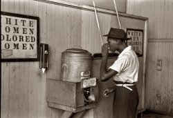 July 1939. "Negro drinking at 'colored' water cooler in Oklahoma City streetcar terminal." View full size. 35mm nitrate negative by Russell Lee.