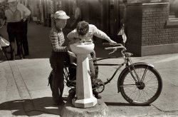 Caldwell, Idaho. The summer of 1941, on or around the Fourth of July. Water fountain outside the bank seen in the post above. View full size. 35mm nitrate negative by Russell Lee for the Farm Security Administration. Slurp.