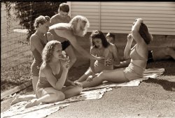 Sunbathers at the city park swimming pool in Caldwell, Idaho. July 1941. The girls are rubbing olive oil on each other. View full size. Photograph by Russell Lee.