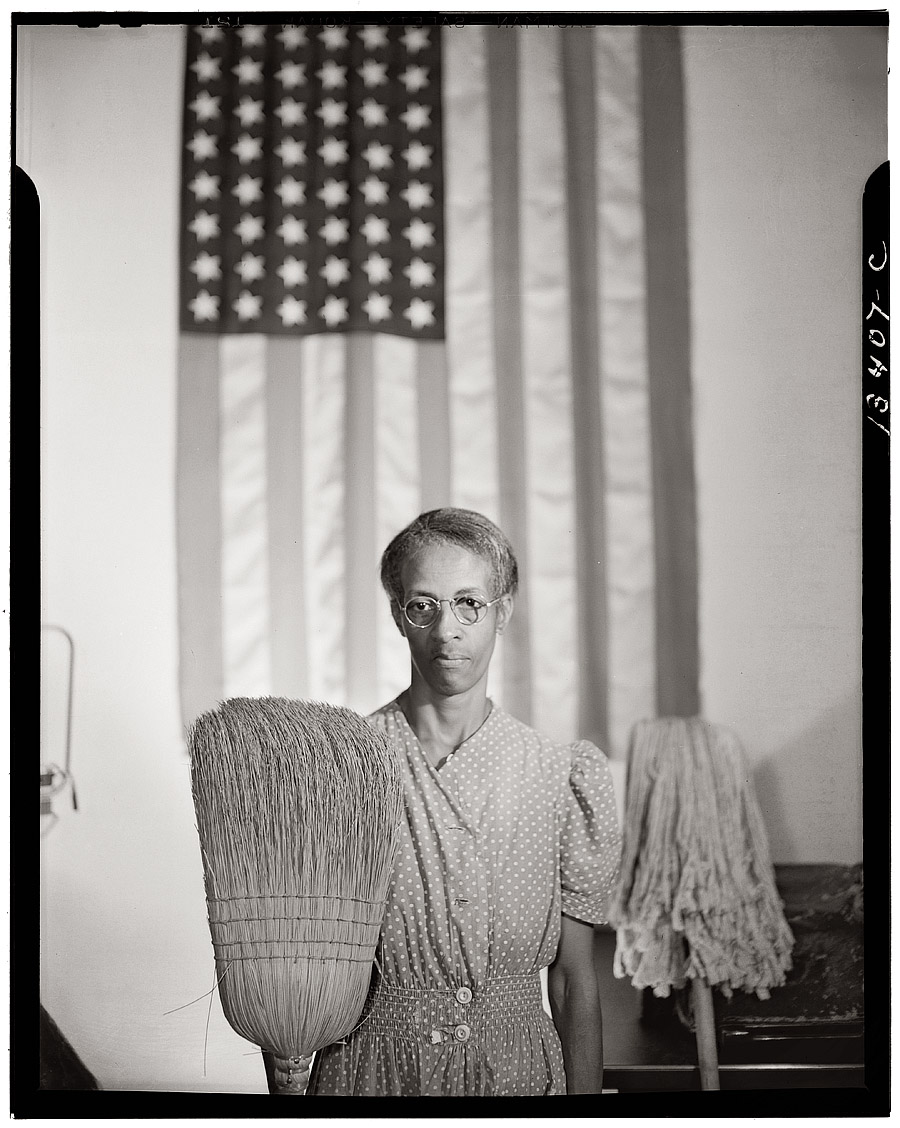 August 1942. "Ella Watson, a charwoman employed by the government in Washington, D.C." Photograph by Gordon Parks, who took dozens of pictures of Mrs. Watson in one of his first assignments for the FSA. View full size.