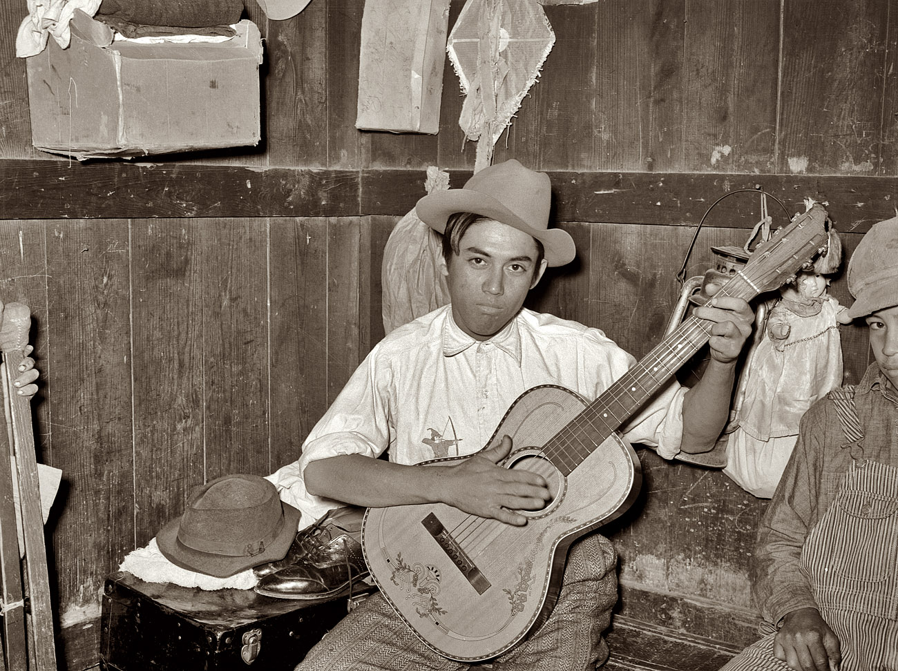 February 1939. Robstown, Texas. Mexican boy playing guitar in room of corral. View full size. Medium-format safety negative by Russell Lee for the FSA.