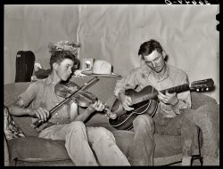 June 1940. Pie Town, New Mexico. "Farmer and his brother making music."  Photo by Russell Lee for the Farm Security Administration. View full size.